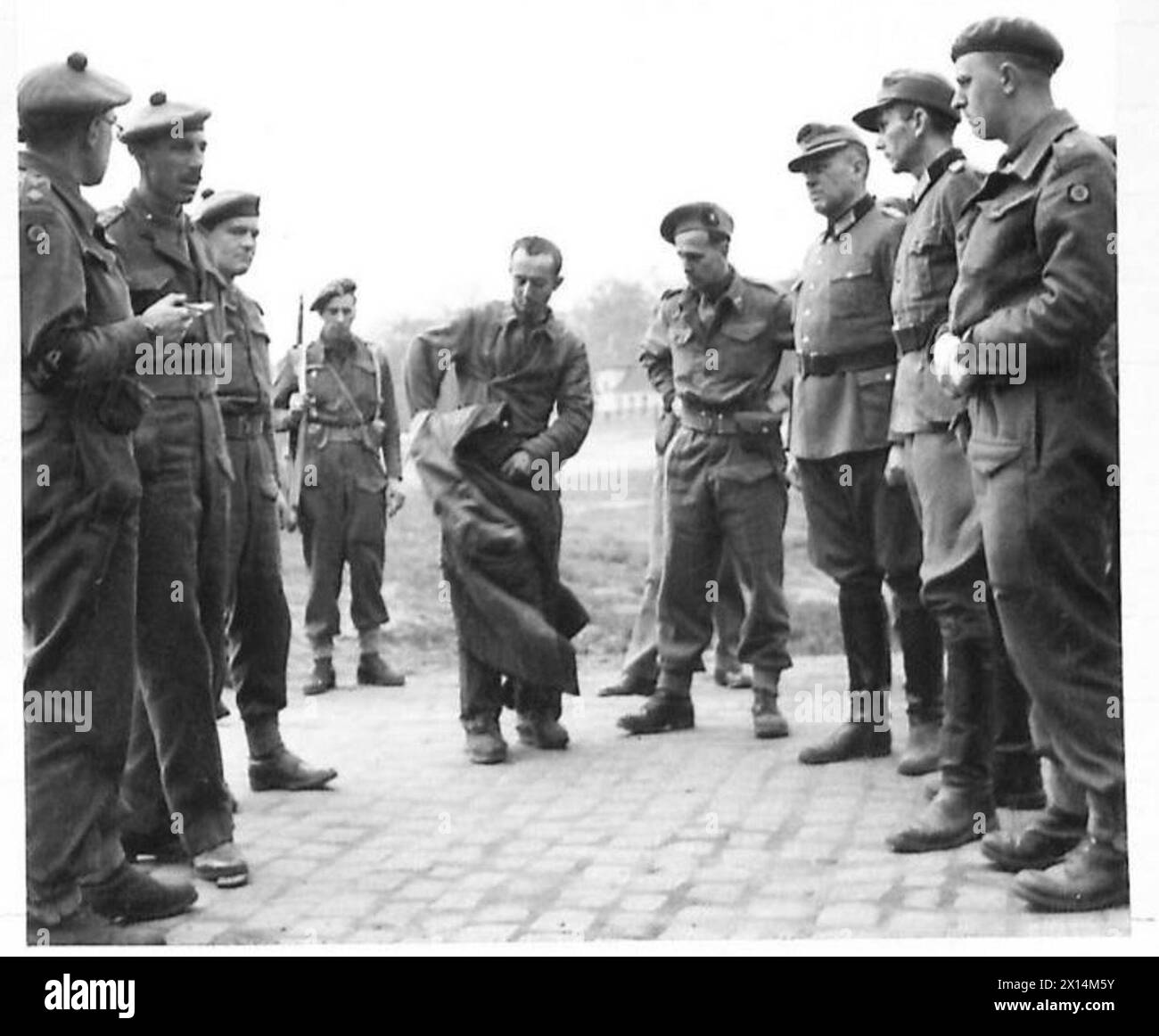 LE TRUPPE IN AVANZATA RAGGIUNGONO CELLE - ufficiali britannici che interrogano i tedeschi. Un ex prigioniero russo ascolta l'esercito britannico, 21st Army Group Foto Stock