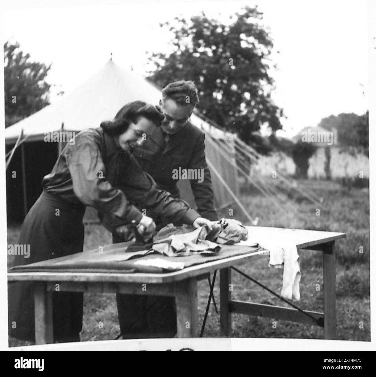 Miss June Worth di ENSA, Manchester, stirare una camicia per Lennox Dalton in Normandia, British Army, 21st Army Group. Foto Stock