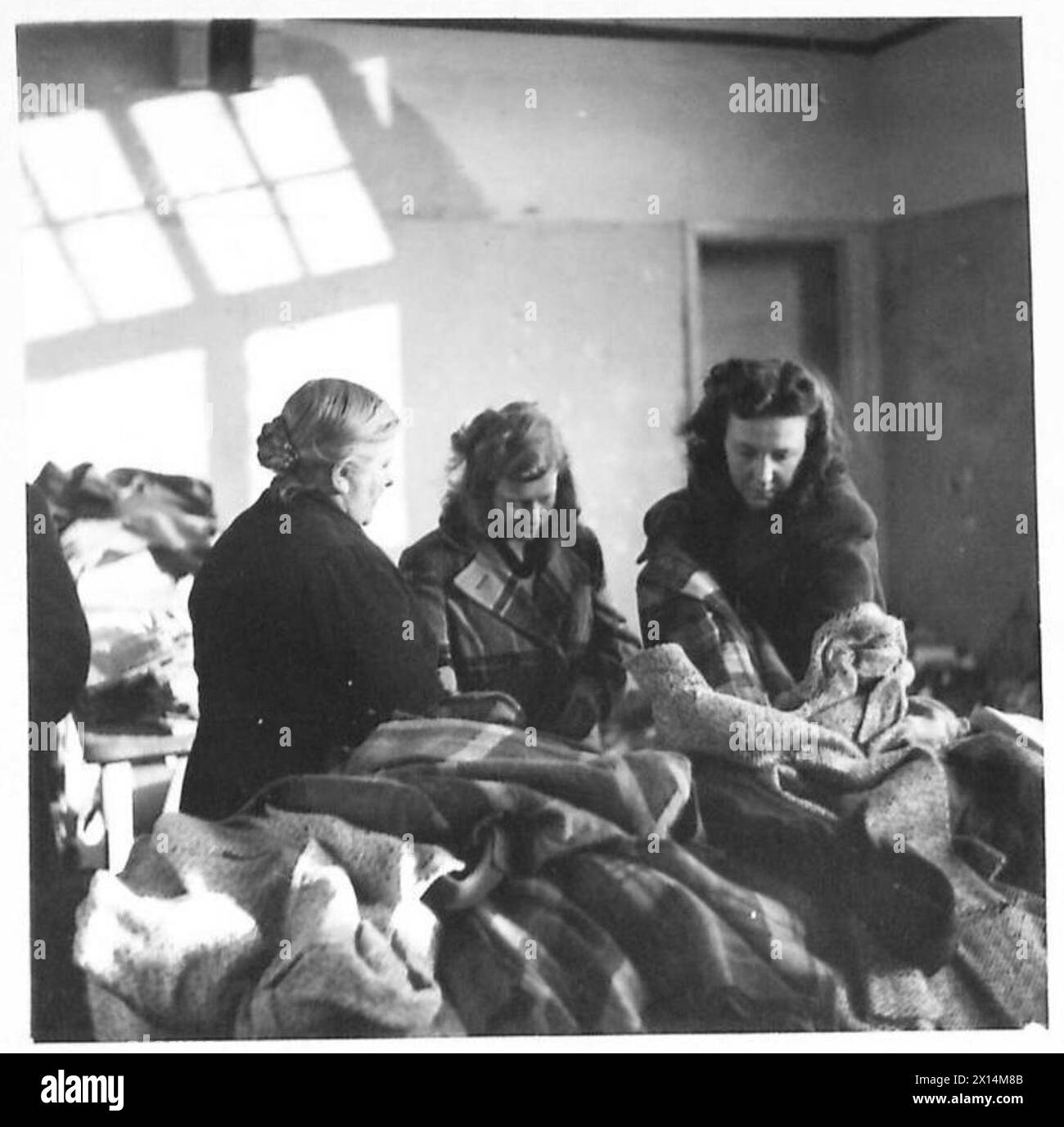 Le ragazze e la loro madre sono dotate di nuovi vestiti forniti dalle forze alleate ai civili olandesi dall'esercito britannico, 21st Army Group. Foto Stock