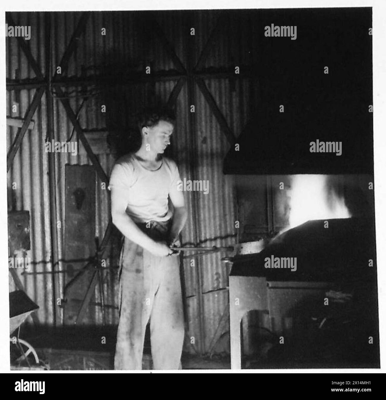 N. B. Davies gestisce la fornace nella bottega del fabbro in un laboratorio di base in Italia. Foto Stock