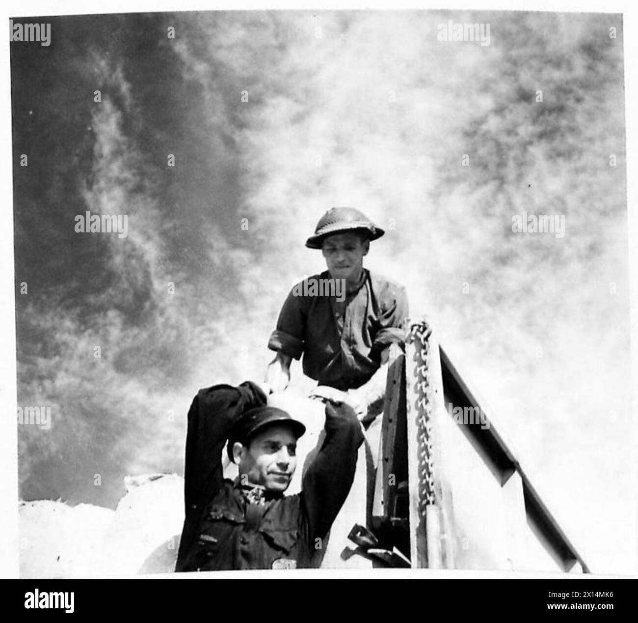 I soldati britannici dell'Ottava Armata assistono al raccolto italiano; l'autista Jenkins trasporta grano dall'ex prigioniero Luigi Manganelli, ex servizio sottomarino italiano. Foto Stock