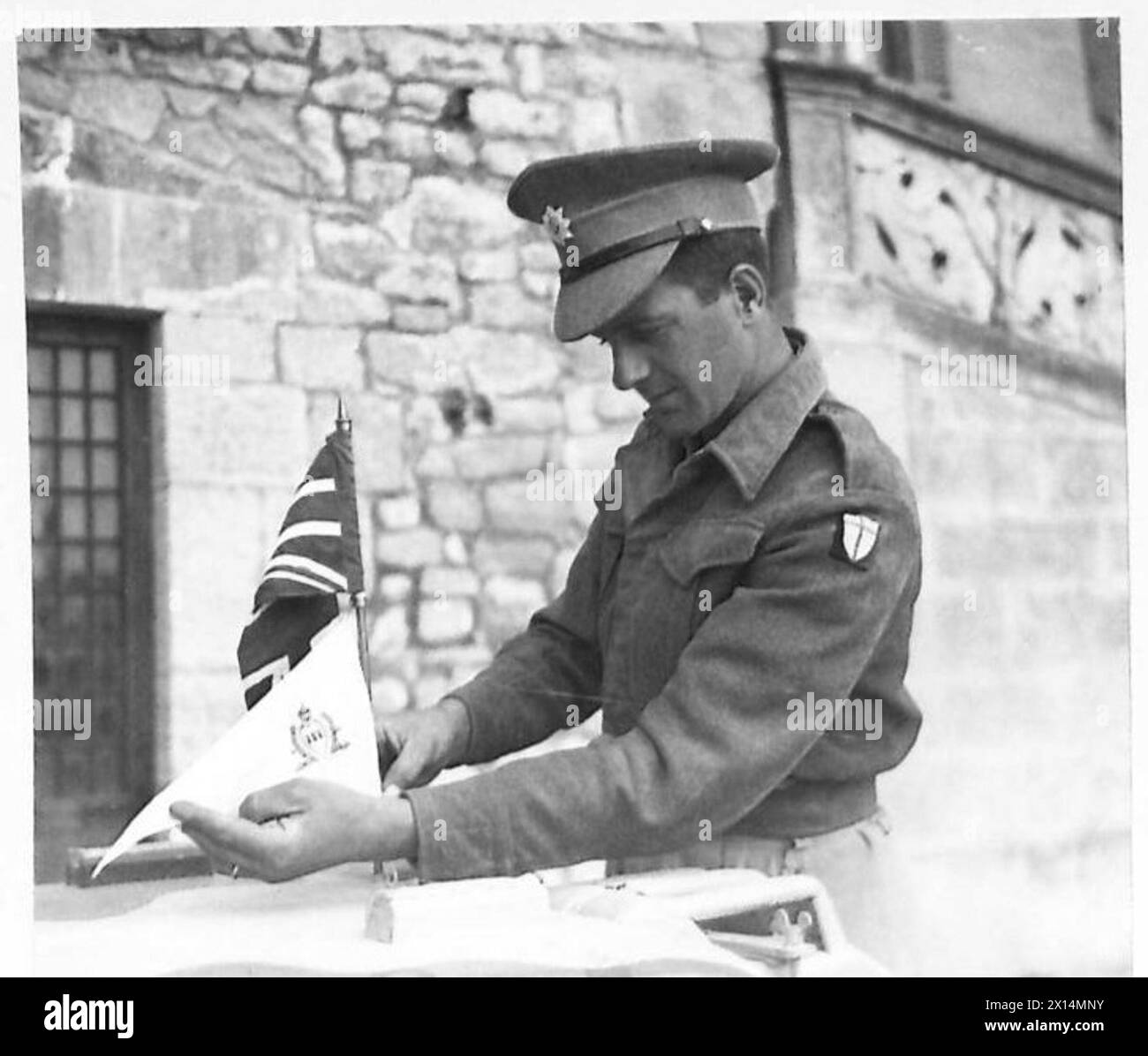 L'autista W. Kershaw attacca la bandiera di San Marino a un pennant Union Jack sulla sua Jeep durante la visita C-in-C a San Marino con il personale dell'esercito britannico. Foto Stock