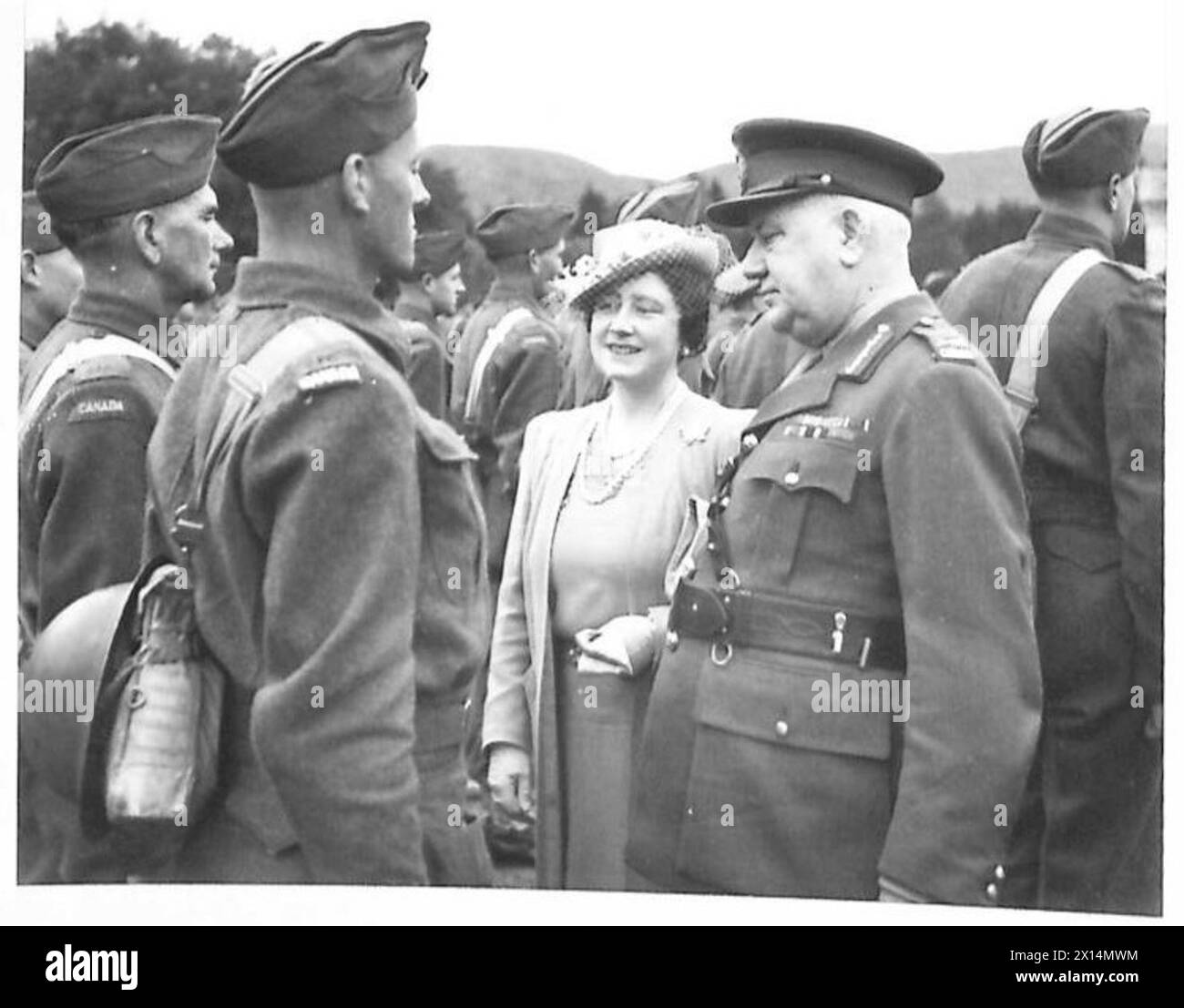 Il re e la regina ispezionarono il Canadian Forestry Corps, con la regina che parlava con alcuni membri del corpo per osservare le operazioni e il personale. Foto Stock