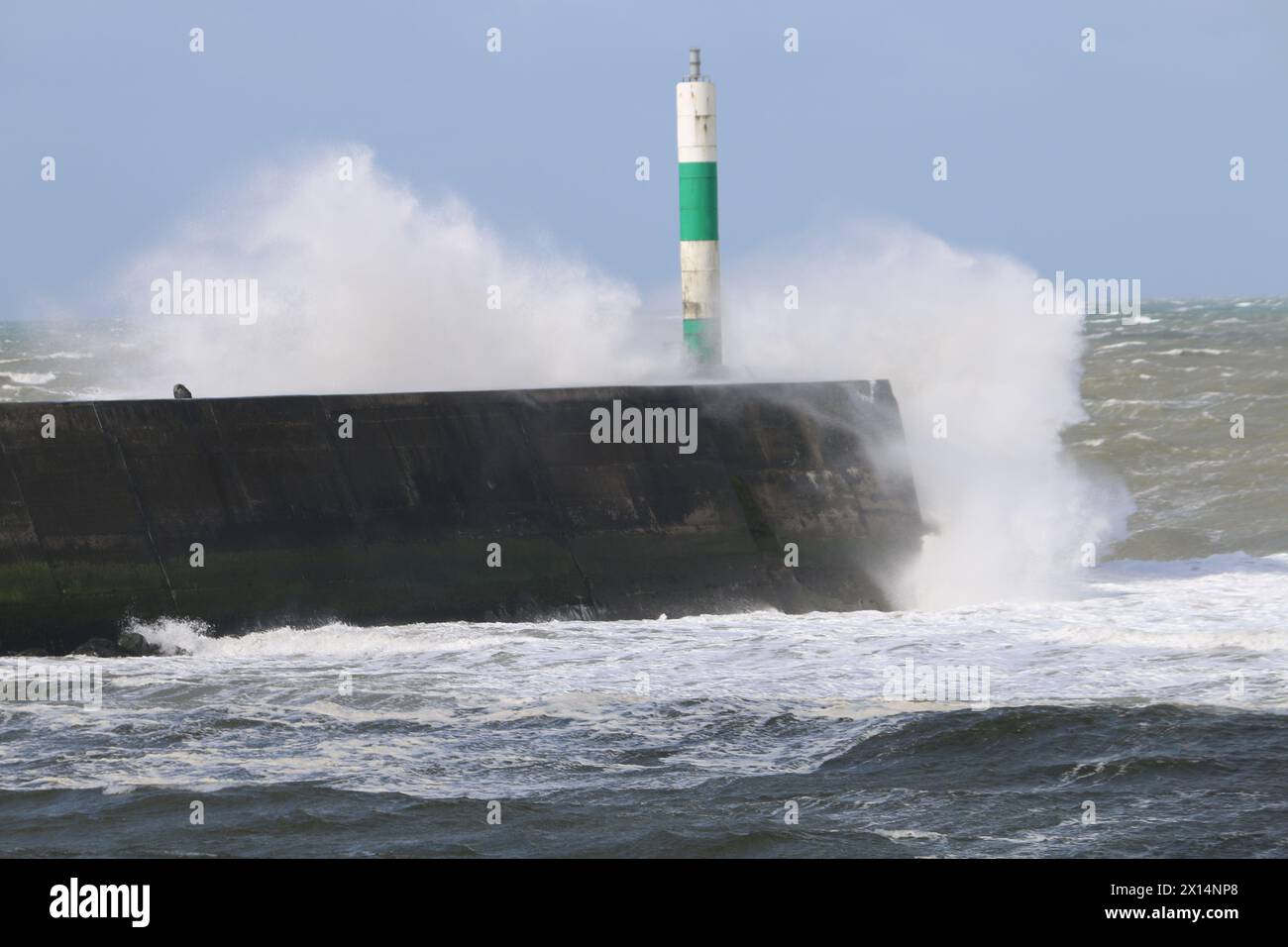 Aberystwyth Galles Regno Unito Meteo 15 aprile 2024. Forti venti di forte forza battono le zone costiere del Galles occidentale guidando in enormi onde che si schiantano contro la passeggiata e le difese portuali di Aberystwyth, credito: mike davies/Alamy Live News Foto Stock