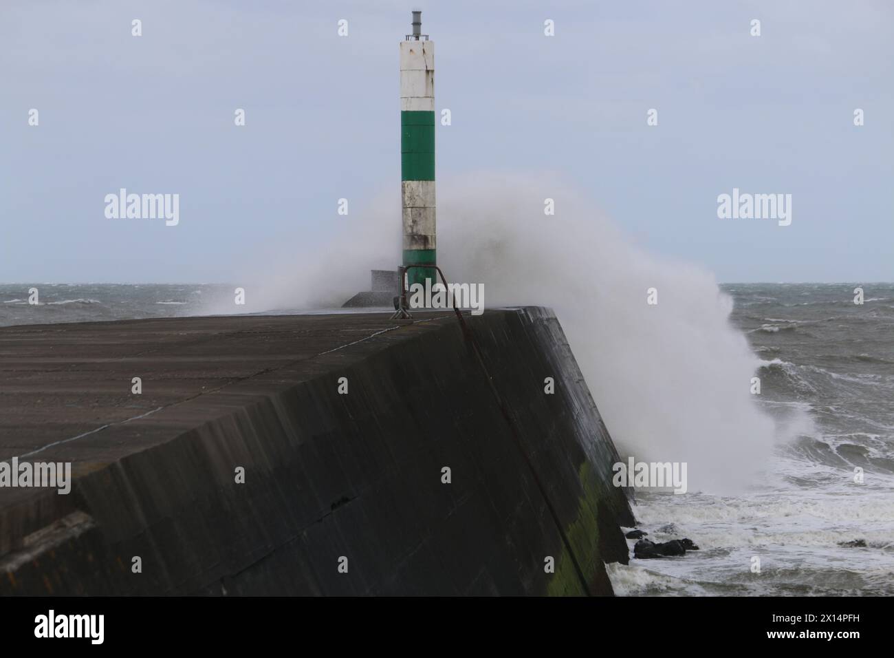 Aberystwyth Galles Regno Unito Meteo 15 aprile 2024. Forti venti di forte forza battono le zone costiere del Galles occidentale guidando in enormi onde che si schiantano contro la passeggiata e le difese portuali di Aberystwyth, credito: mike davies/Alamy Live News Foto Stock