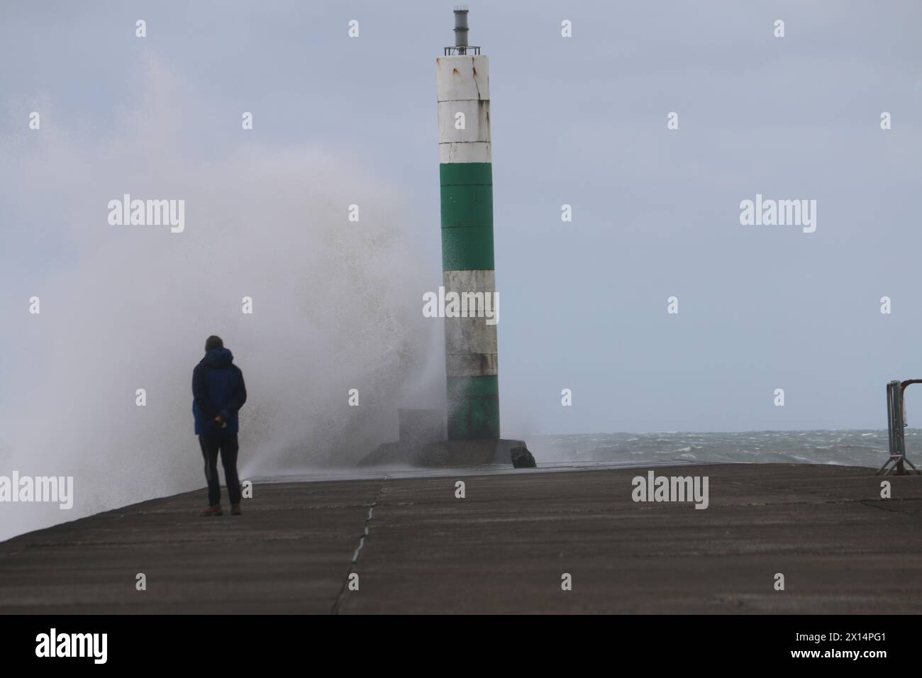 Aberystwyth Galles Regno Unito Meteo 15 aprile 2024. Forti venti di forte forza battono le zone costiere del Galles occidentale guidando in enormi onde che si schiantano contro la passeggiata e le difese portuali di Aberystwyth, credito: mike davies/Alamy Live News Foto Stock