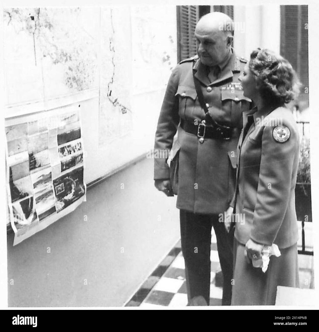 Il generale Wilson, comandante in capo, esamina una mappa di guerra con la signorina Raye Sylvester, rappresentante della Croce Rossa americana, presso gli stabilimenti del Nord Africa. Foto Stock