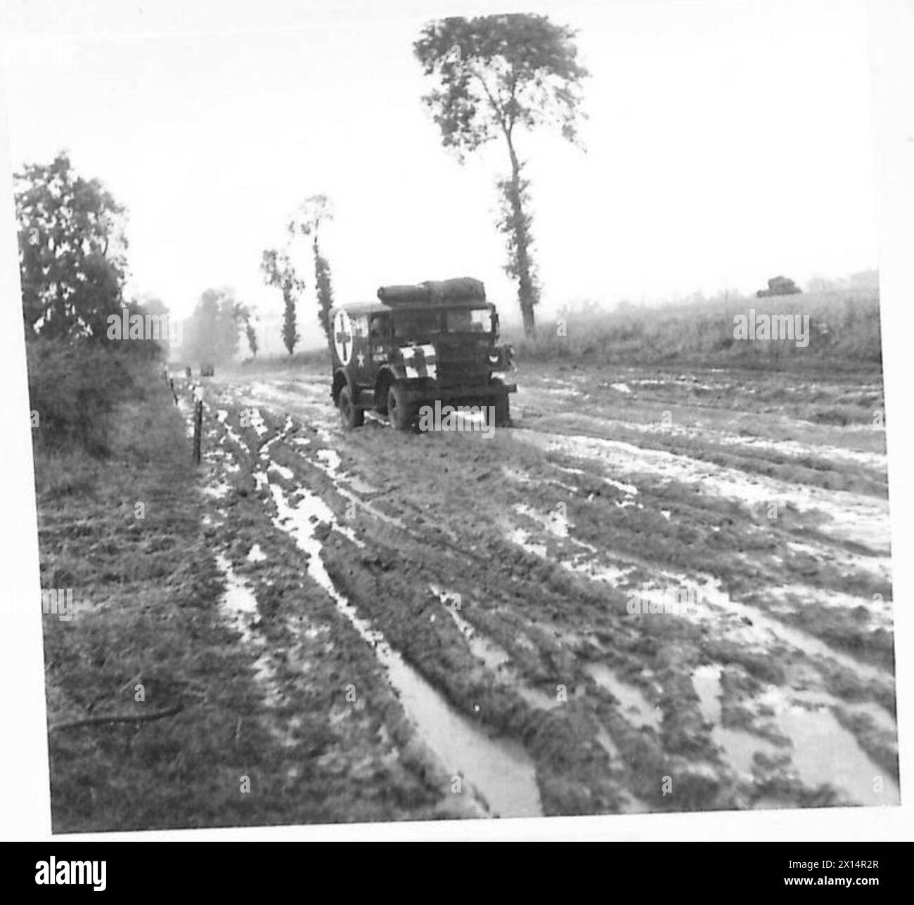 I veicoli e il personale dell'esercito britannico navigano su strade fangose tra Troarn e Banneville in Normandia, dimostrando sfide logistiche e operative durante il movimento post-combattimento, 21st Army Group. Foto Stock