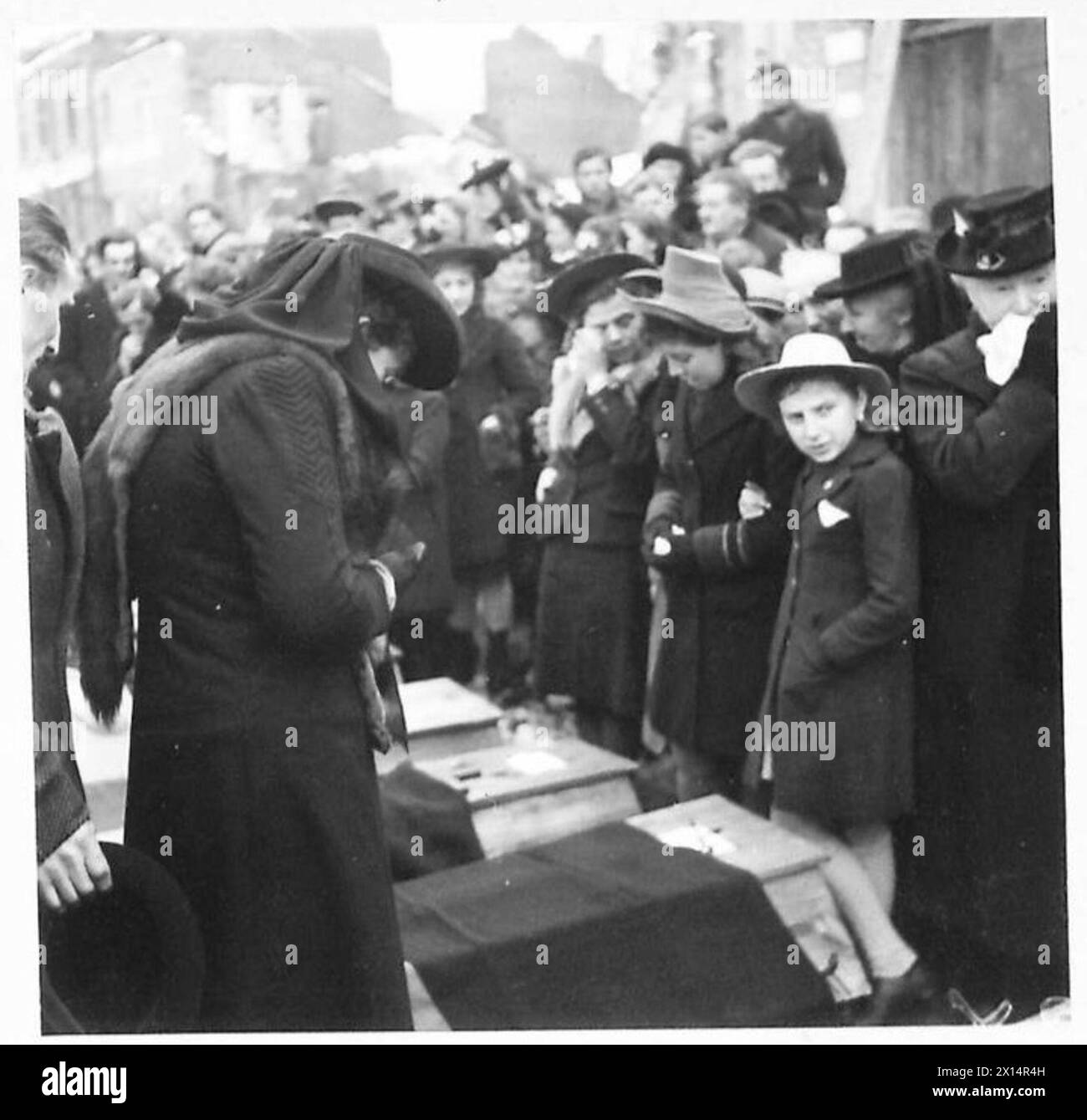 FUNERALE DELLE VITTIME della "BANDA" - le donne in lutto delle vittime, stanno pateticamente accanto alle bare dei loro cari, British Army, 21st Army Group Foto Stock