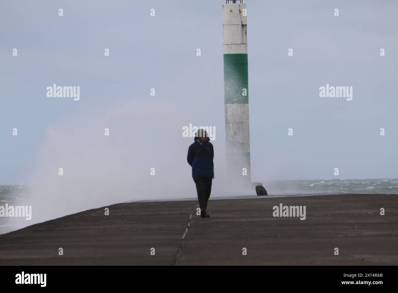 Aberystwyth Galles Regno Unito Meteo 15 aprile 2024. Forti venti di forte forza battono le zone costiere del Galles occidentale guidando in enormi onde che si schiantano contro la passeggiata e le difese portuali di Aberystwyth, credito: mike davies/Alamy Live News Foto Stock