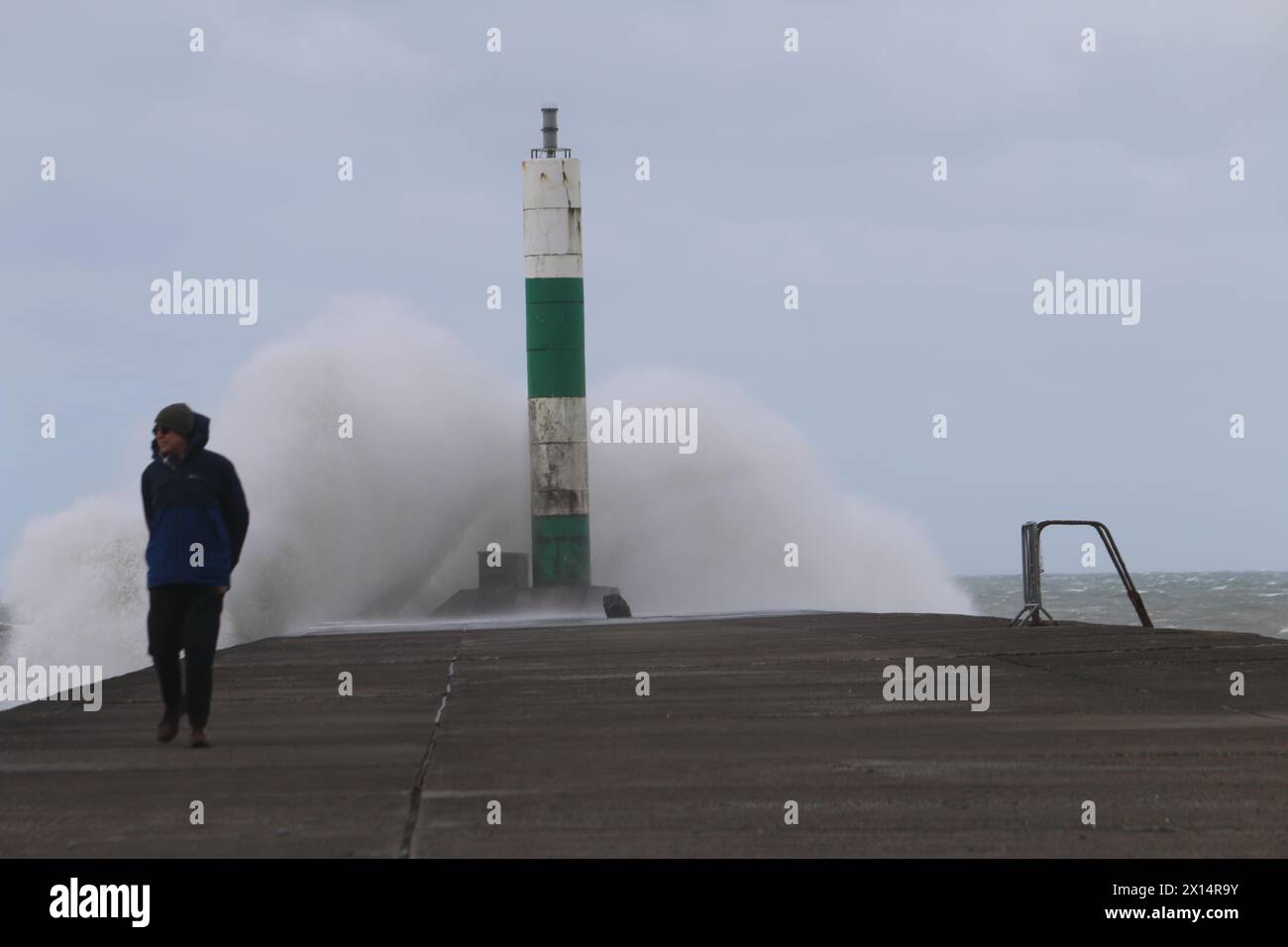 Aberystwyth Galles Regno Unito Meteo 15 aprile 2024. Forti venti di forte forza battono le zone costiere del Galles occidentale guidando in enormi onde che si schiantano contro la passeggiata e le difese portuali di Aberystwyth, credito: mike davies/Alamy Live News Foto Stock