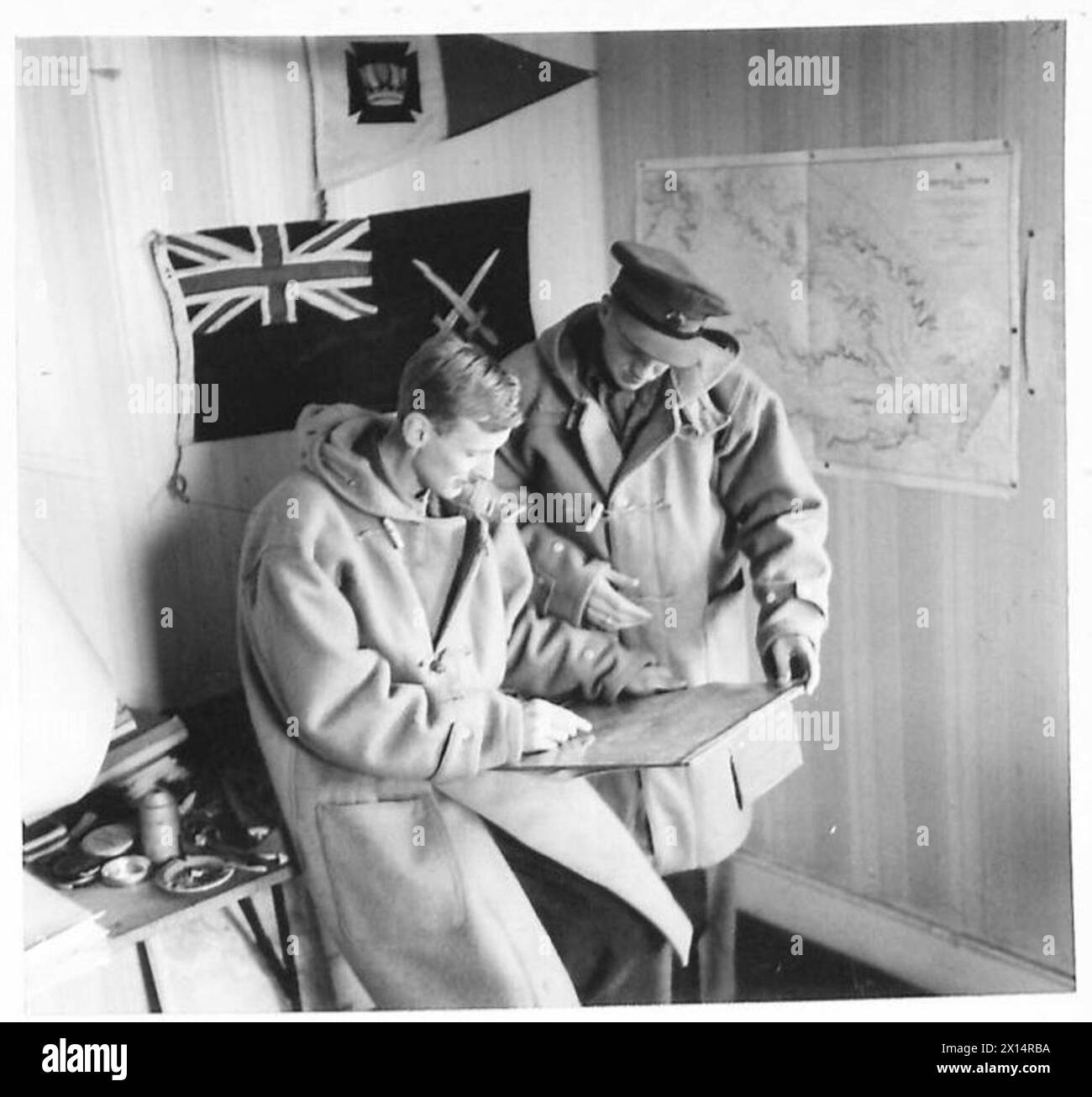 Il personale dell'esercito britannico discute delle operazioni notturne presso il quartier generale, coordinando piani e strategie. Foto Stock