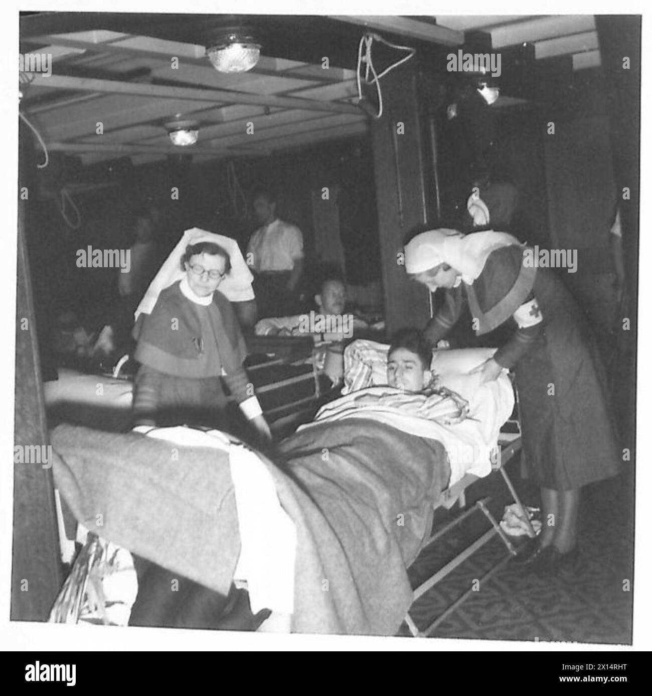 Un prigioniero di guerra tedesco è curato da infermieri a bordo di una nave ospedale prima del rimpatrio, British Army. Foto Stock