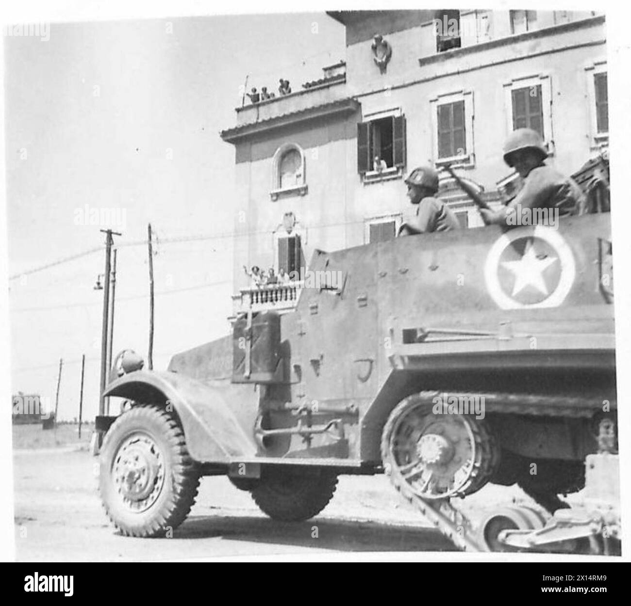 Le truppe alleate della Quinta Armata avanzano attraverso i sobborghi di Roma, mentre i residenti italiani osservano e tifo dai balconi delle case. Foto Stock
