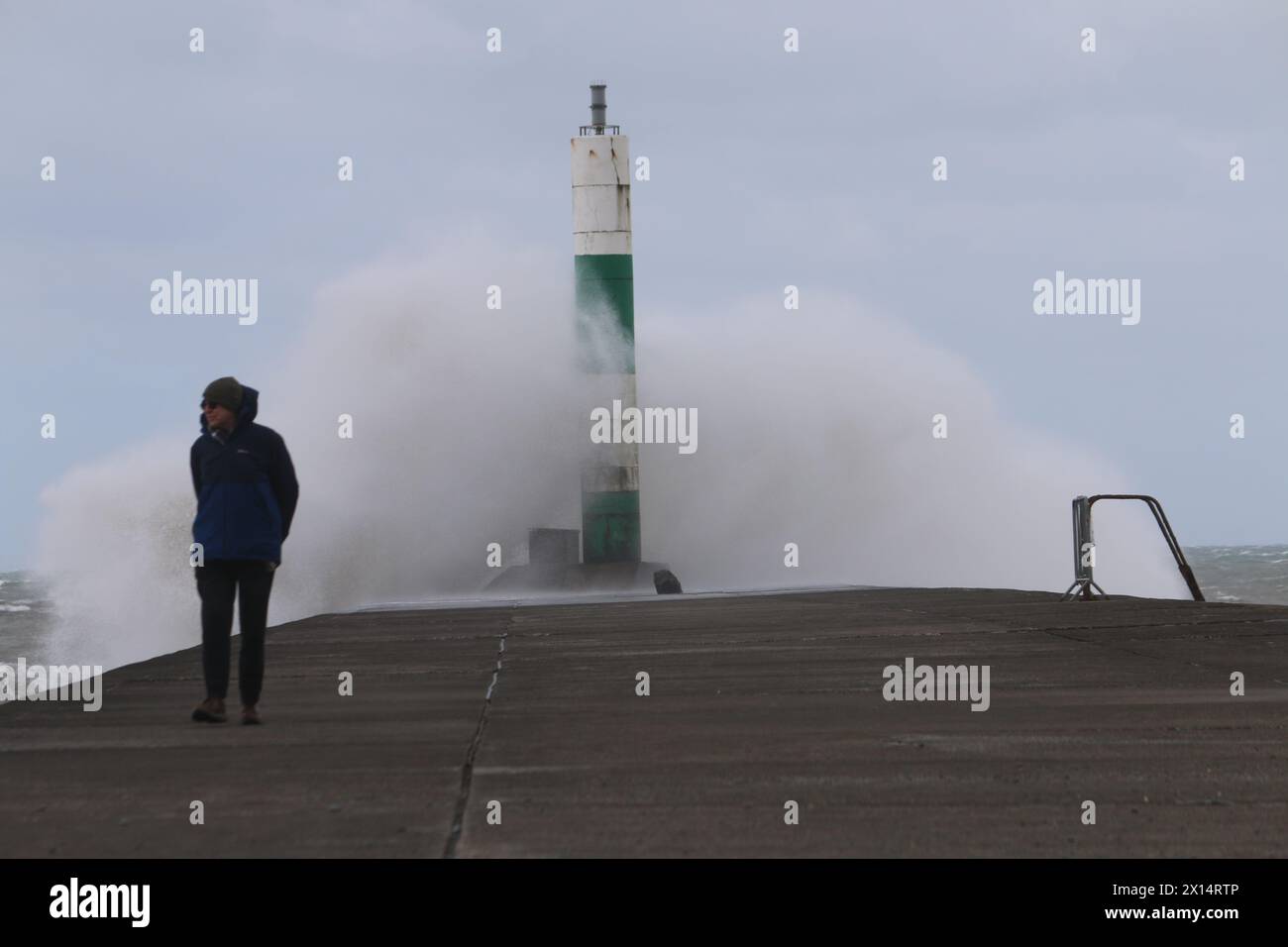 Aberystwyth Galles Regno Unito Meteo 15 aprile 2024. Forti venti di forte forza battono le zone costiere del Galles occidentale guidando in enormi onde che si schiantano contro la passeggiata e le difese portuali di Aberystwyth, credito: mike davies/Alamy Live News Foto Stock