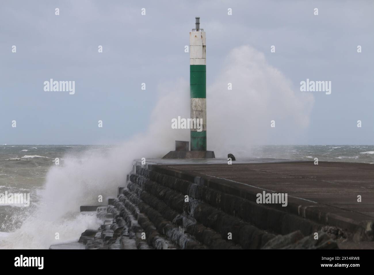 Aberystwyth Galles Regno Unito Meteo 15 aprile 2024. Forti venti di forte forza battono le zone costiere del Galles occidentale guidando in enormi onde che si schiantano contro la passeggiata e le difese portuali di Aberystwyth, credito: mike davies/Alamy Live News Foto Stock