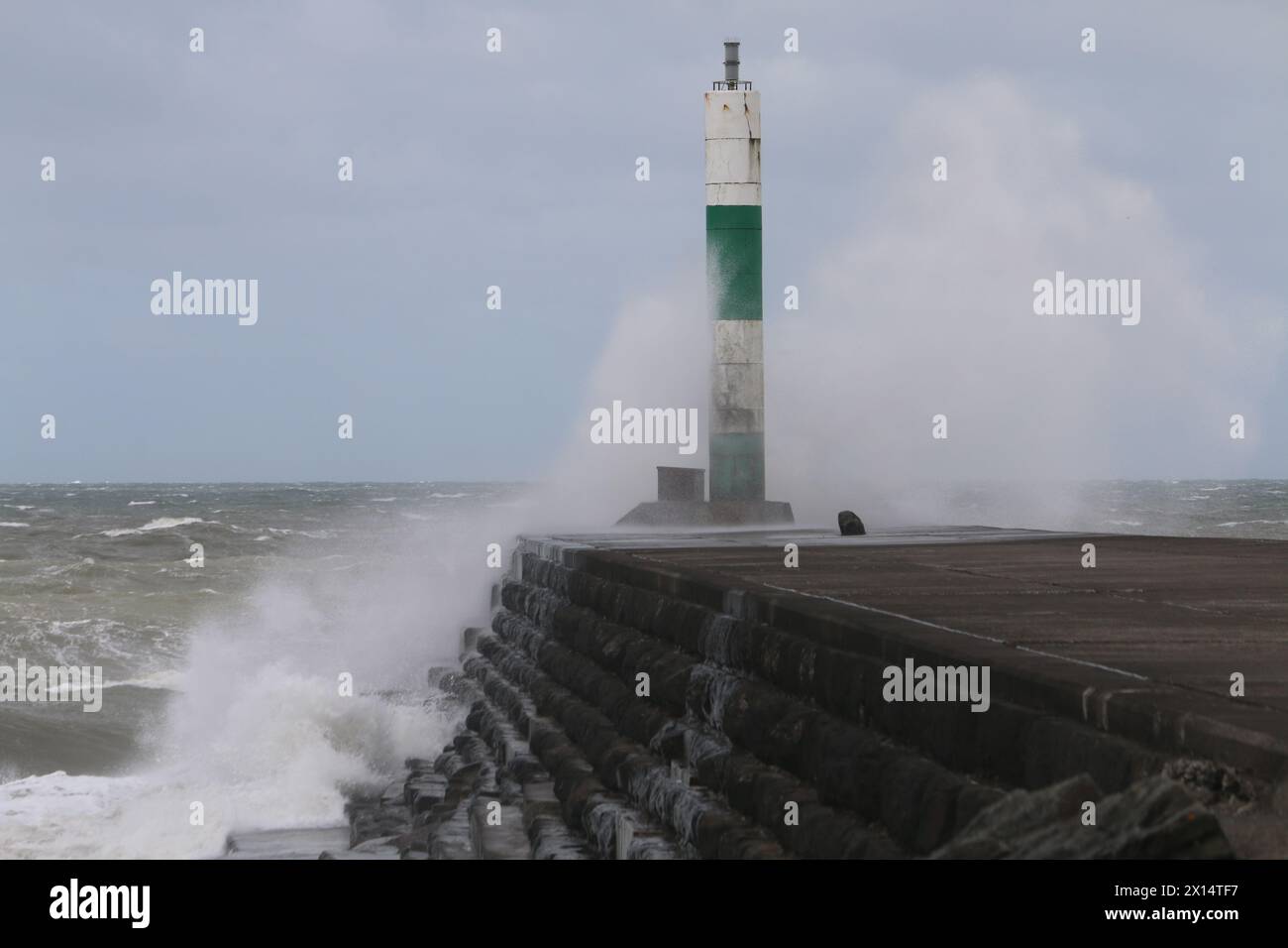 Aberystwyth Galles Regno Unito Meteo 15 aprile 2024. Forti venti di forte forza battono le zone costiere del Galles occidentale guidando in enormi onde che si schiantano contro la passeggiata e le difese portuali di Aberystwyth, credito: mike davies/Alamy Live News Foto Stock