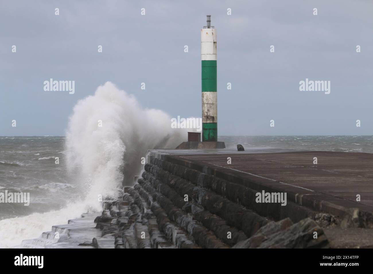 Aberystwyth Galles Regno Unito Meteo 15 aprile 2024. Forti venti di forte forza battono le zone costiere del Galles occidentale guidando in enormi onde che si schiantano contro la passeggiata e le difese portuali di Aberystwyth, credito: mike davies/Alamy Live News Foto Stock