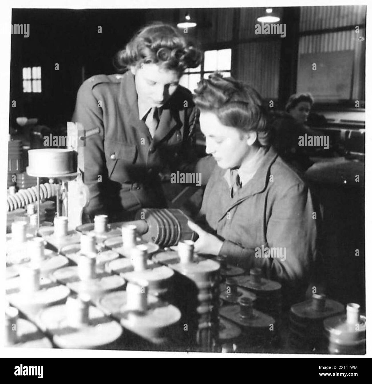 I membri ATS testano i vecchi contenitori del respiratore presso un deposito RAOC utilizzando un manometro tester per assicurarsi che possano resistere agli attacchi di gas, con Pte. Joan Halfpenny che gestisce le attrezzature e Lance Caporale Dorren che controlla il suo lavoro. Foto Stock