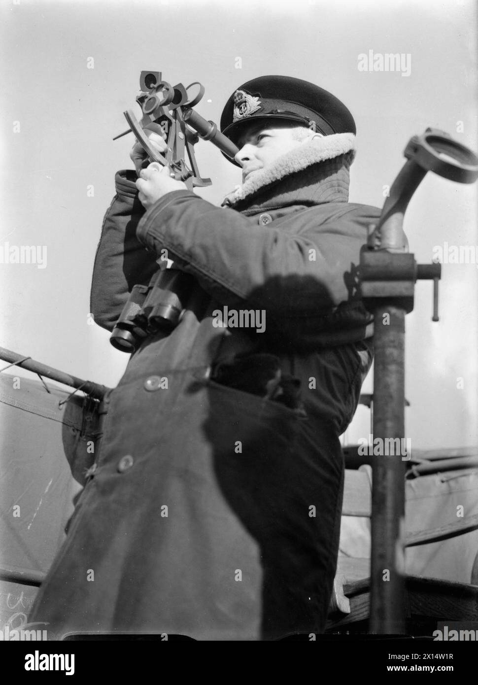 LA ROYAL NAVY DURANTE LA SECONDA GUERRA MONDIALE - l'ufficiale navigante della HMCS NIAGARA usa un sestante per avere una rotta in mare. Indossa un cappotto pesante per proteggerlo dal freddo del ponte aperto Royal Canadian Navy, NIAGARA (HMCS) Foto Stock