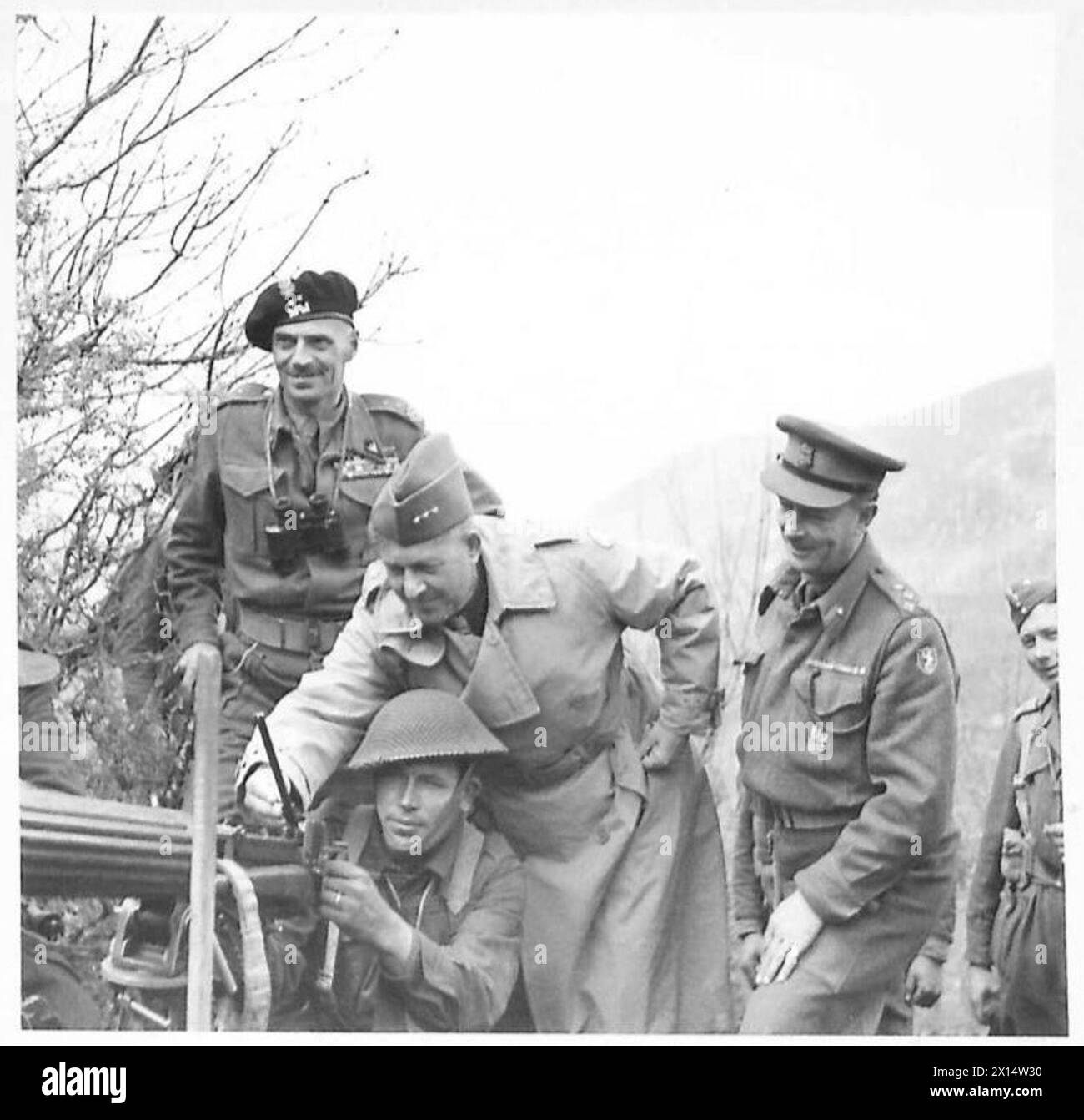 Il generale Jacob Devers esamina una mitragliatrice Vickers usata da un soldato della 6a Brigata di fanteria "Lwów", 5a Divisione Kresowa, 2° corpo polacco durante un'esercitazione, accompagnato dal generale Władysław Anders e dal brigadiere Eric Frith. Fotografia scattata durante una visita alle unità delle forze alleate. Foto Stock