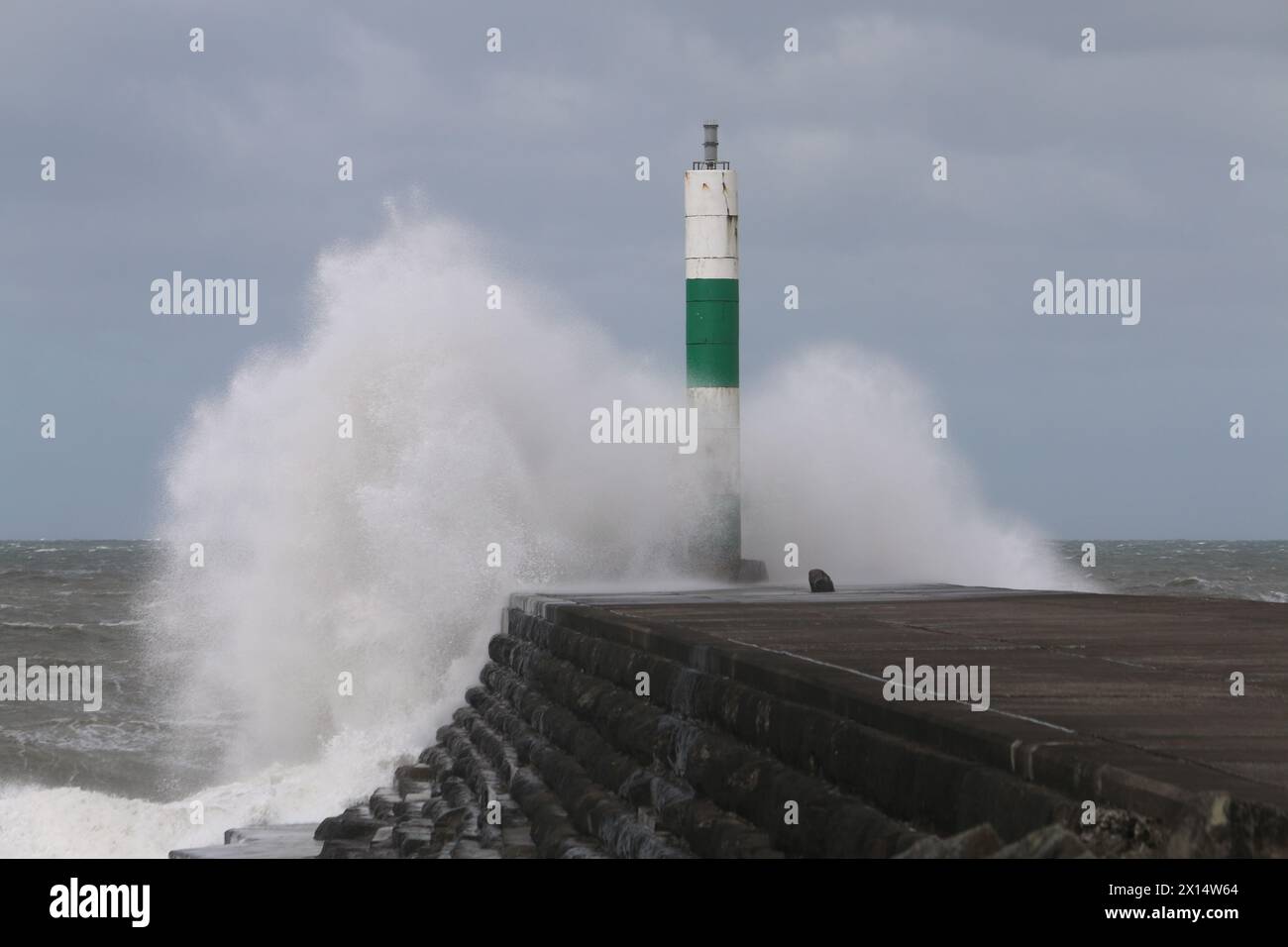Aberystwyth Galles Regno Unito Meteo 15 aprile 2024. Forti venti di forte forza battono le zone costiere del Galles occidentale guidando in enormi onde che si schiantano contro la passeggiata e le difese portuali di Aberystwyth, credito: mike davies/Alamy Live News Foto Stock