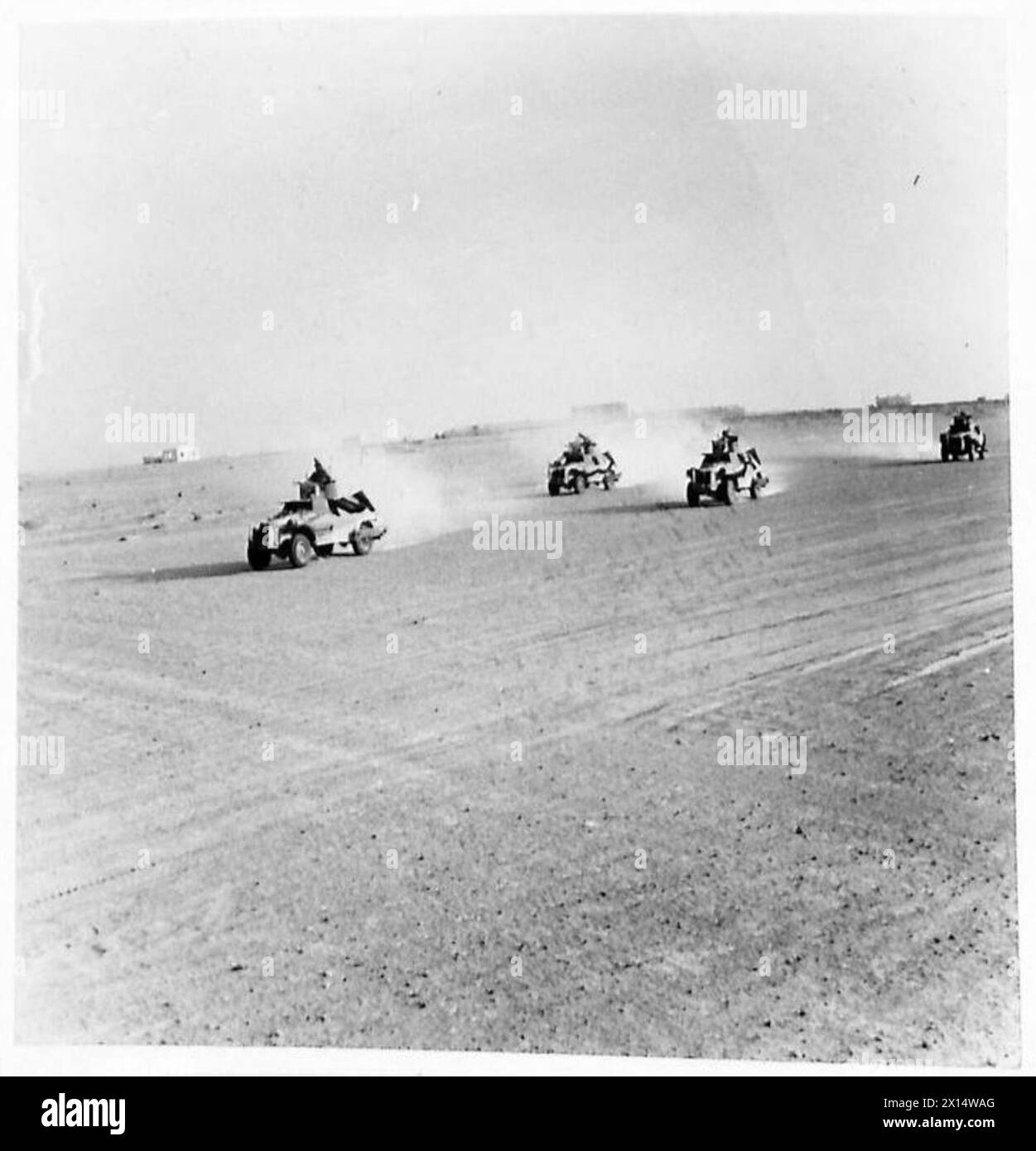 Le auto blindate attraversano il deserto alla ricerca del nemico, fotografate da un fotografo ufficiale dell'esercito britannico. Foto Stock
