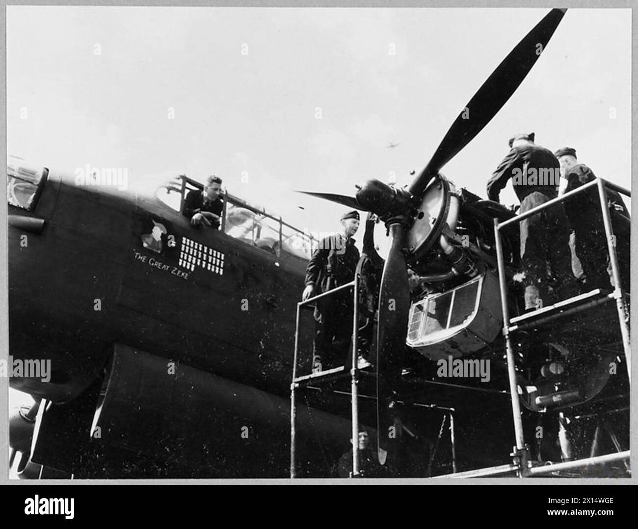 Nel 1943, i meccanici di volo eseguirono la manutenzione su uno dei quattro motori di un bombardiere Lancaster per la Royal Air Force. Foto Stock