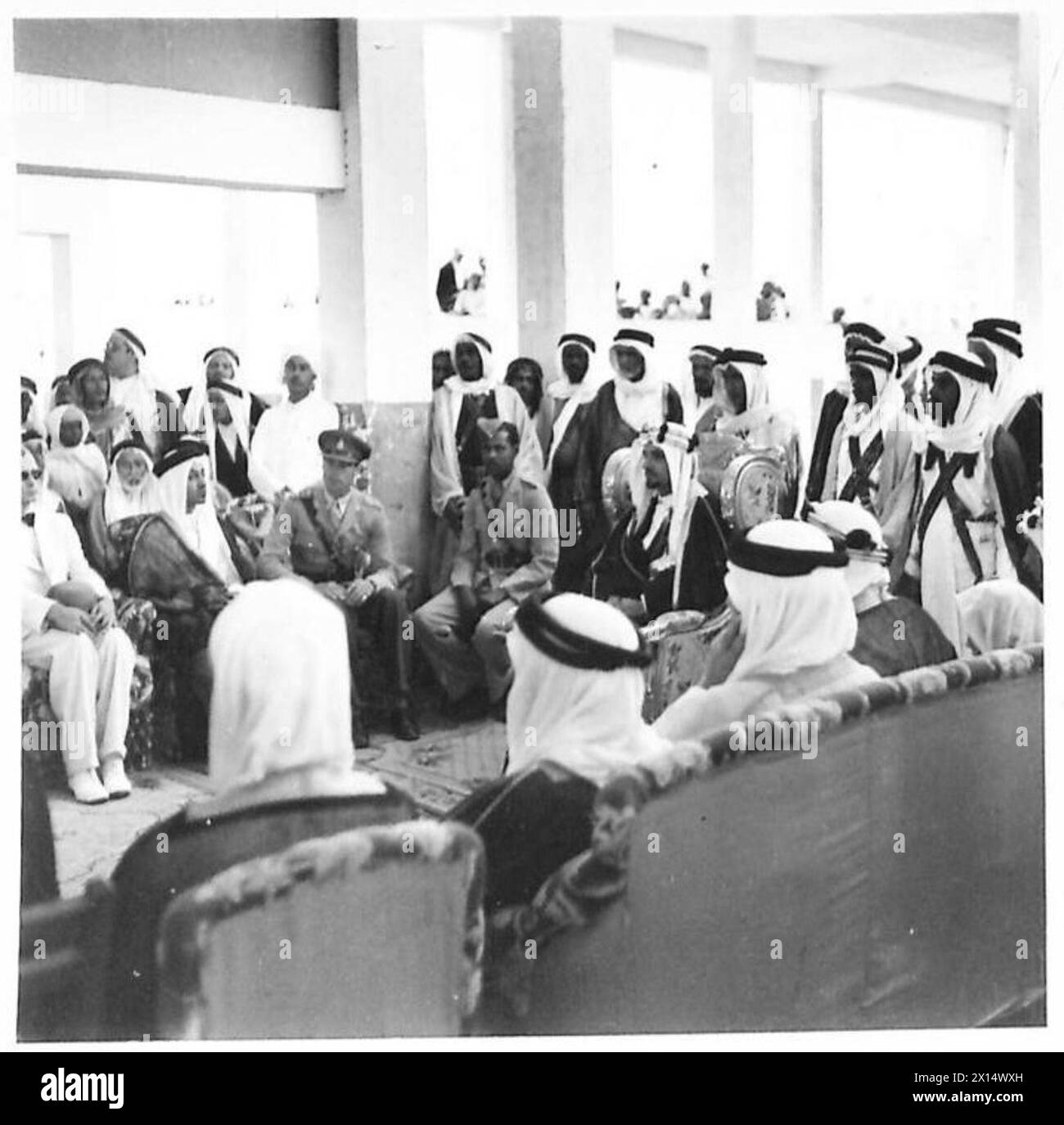 L'Emiro Mansur bin 'Abd al-'Aziz ascolta un discorso di addio del Governatore di Jeddah mentre si siede sulla banchina durante un tour. Foto Stock