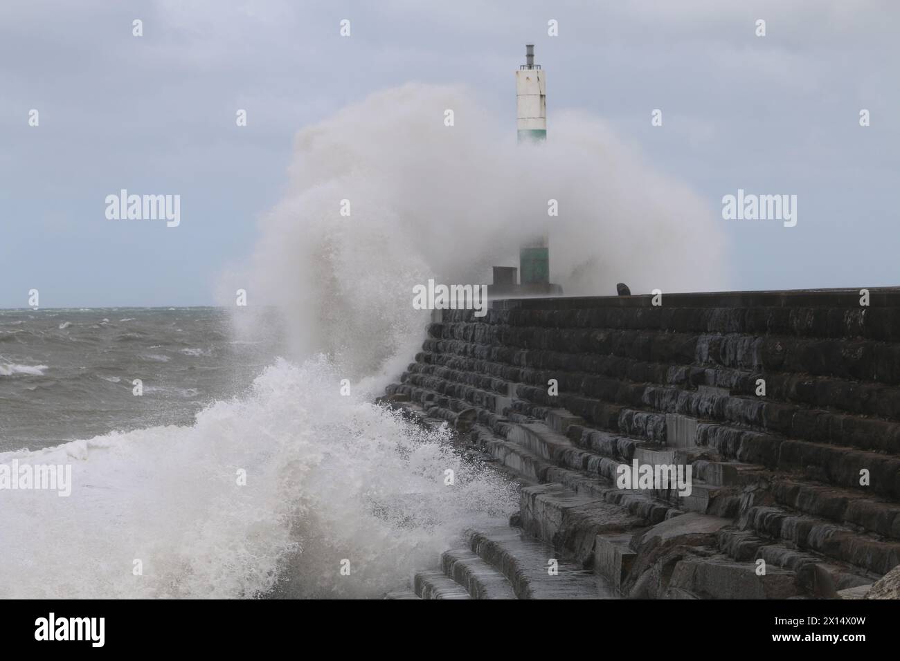 Aberystwyth Galles Regno Unito Meteo 15 aprile 2024. Forti venti di forte forza battono le zone costiere del Galles occidentale guidando in enormi onde che si schiantano contro la passeggiata e le difese portuali di Aberystwyth, credito: mike davies/Alamy Live News Foto Stock