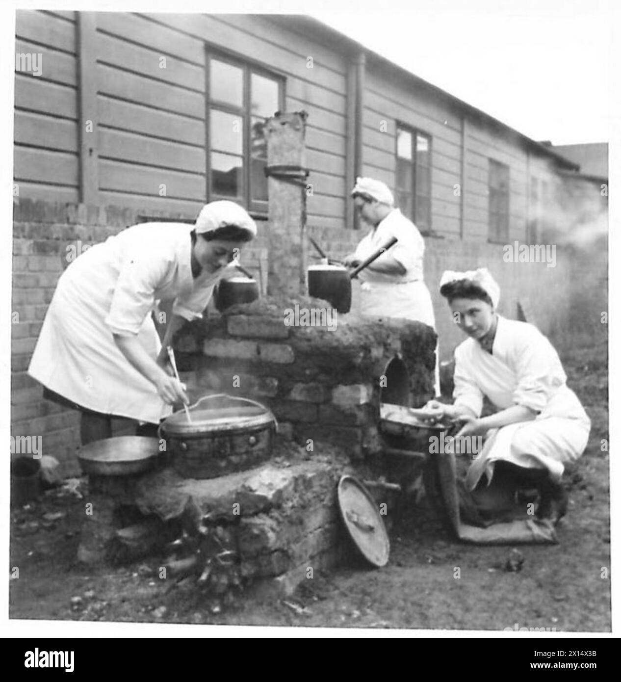 Un cuoco prova i rotoli in una cucina da campo tipo forno a tamburo utilizzata per cuocere o bollire presso la ATS Cookery School. Foto Stock
