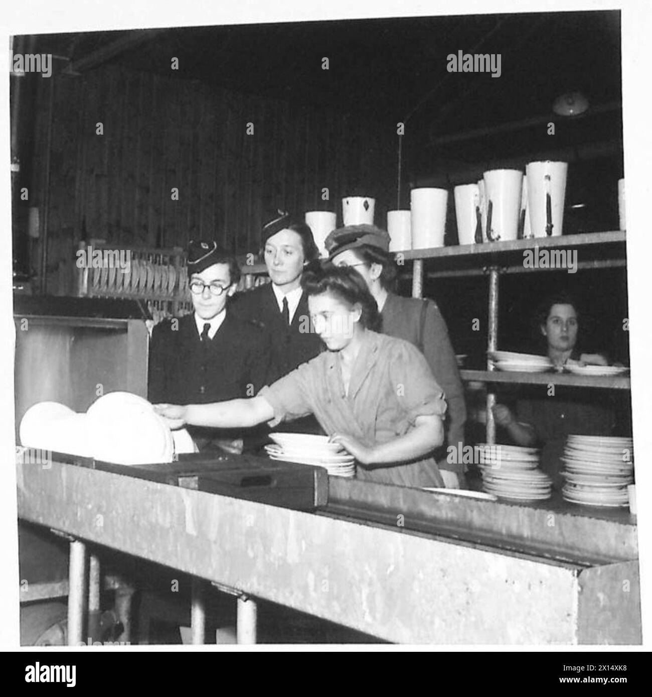 Gli ausiliari del servizio territoriale ausiliario sono osservati dagli ufficiali durante le attività di addestramento del fine settimana presso un centro di addestramento militare cookhouse. Foto Stock