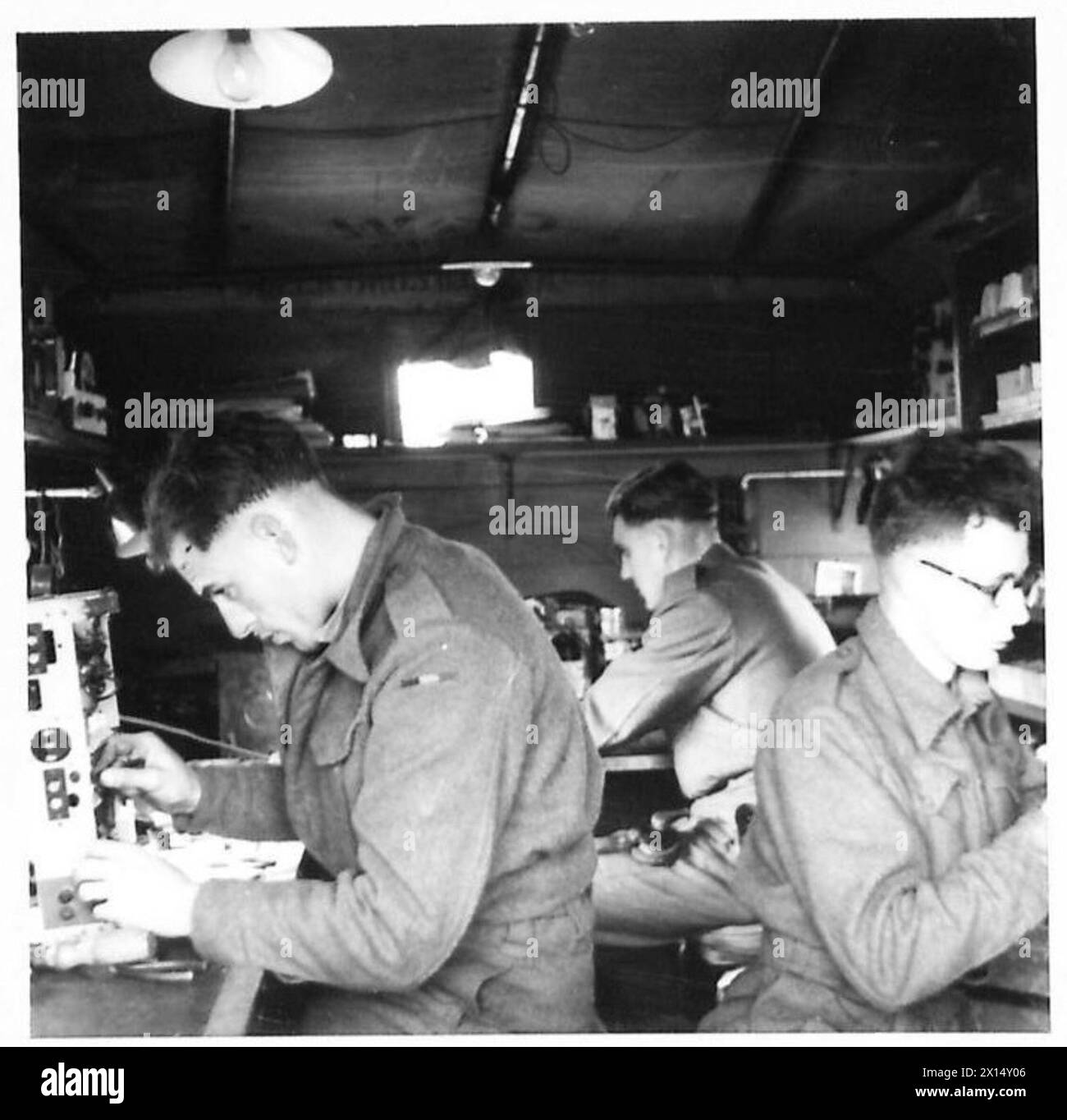 All'interno delle officine di riparazione wireless Fifth Army REME, CFN. Albert Hook seleziona pezzi di ricambio, CFN. A. Cameron ripara un ricevitore GEC e CFN. D. Francis lavora sullo sfondo. Foto Stock