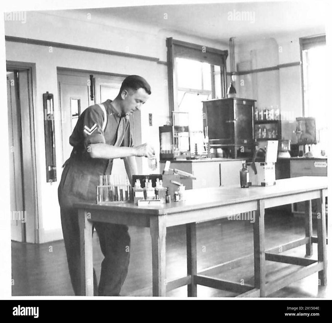 Un caporale che lavora nel laboratorio della School of Hygiene di Aldershot, British Army, concentrandosi sulla formazione medica e sanitaria. Foto Stock