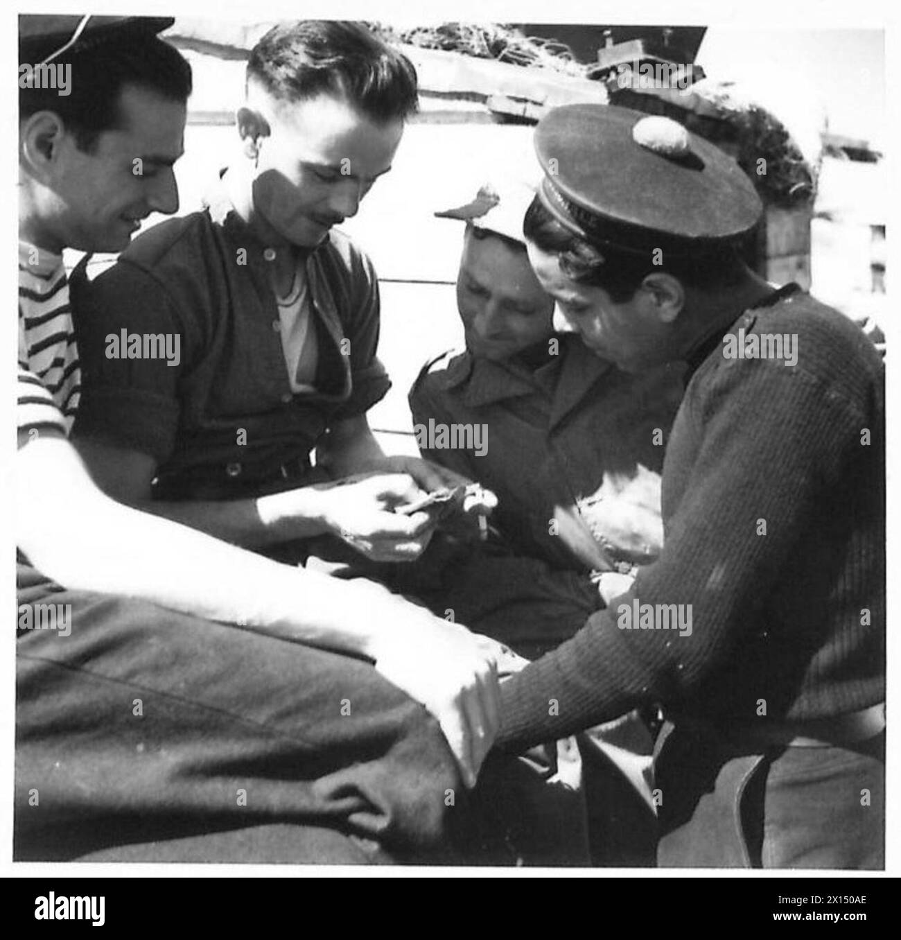 Gli equipaggi di armi alleate collaborano nelle operazioni di difesa del forte, gestendo al contempo le differenze linguistiche, dimostrando il coordinamento e la cooperazione multinazionale. Foto Stock