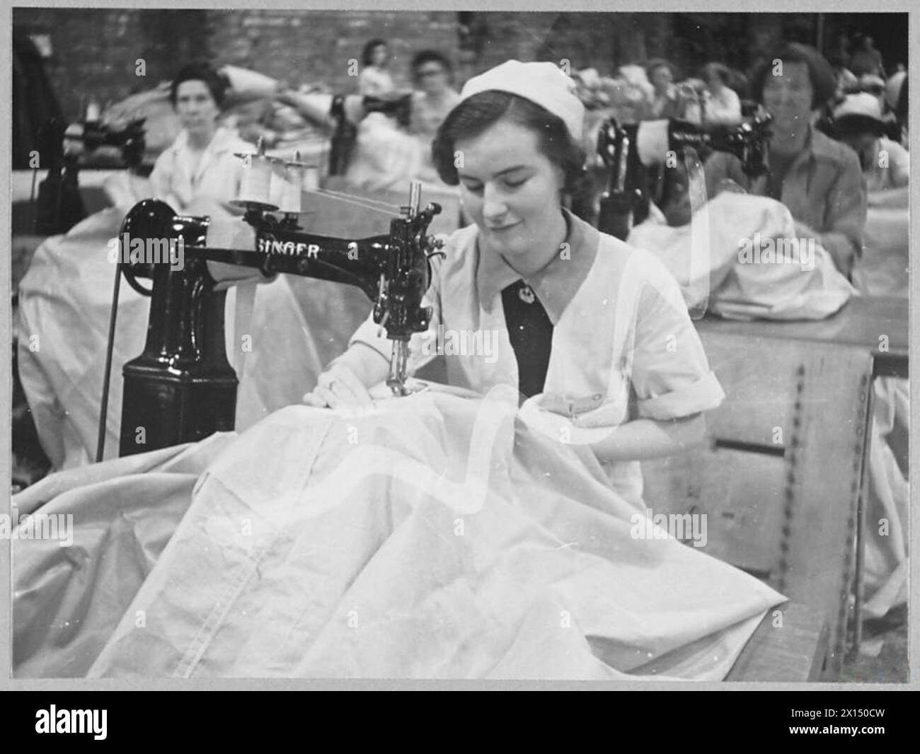 Una sarta attacca il tessuto di lino alla fusoliera di un bombardiere Wellington in una struttura di assemblaggio della Royal Air Force. Negativo fotografico, Royal Air Force. Foto Stock