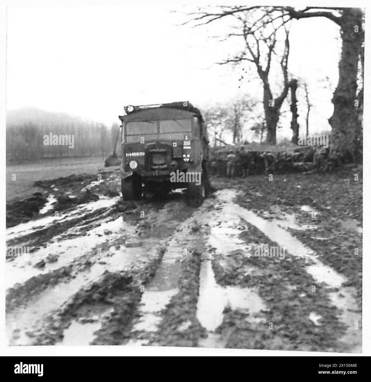 Un trasportatore britannico di armi da campo medio si muove attraverso il fango e l'acqua sulla strada a Roccamonfina, con un cannone americano visibile nelle vicinanze. Foto Stock