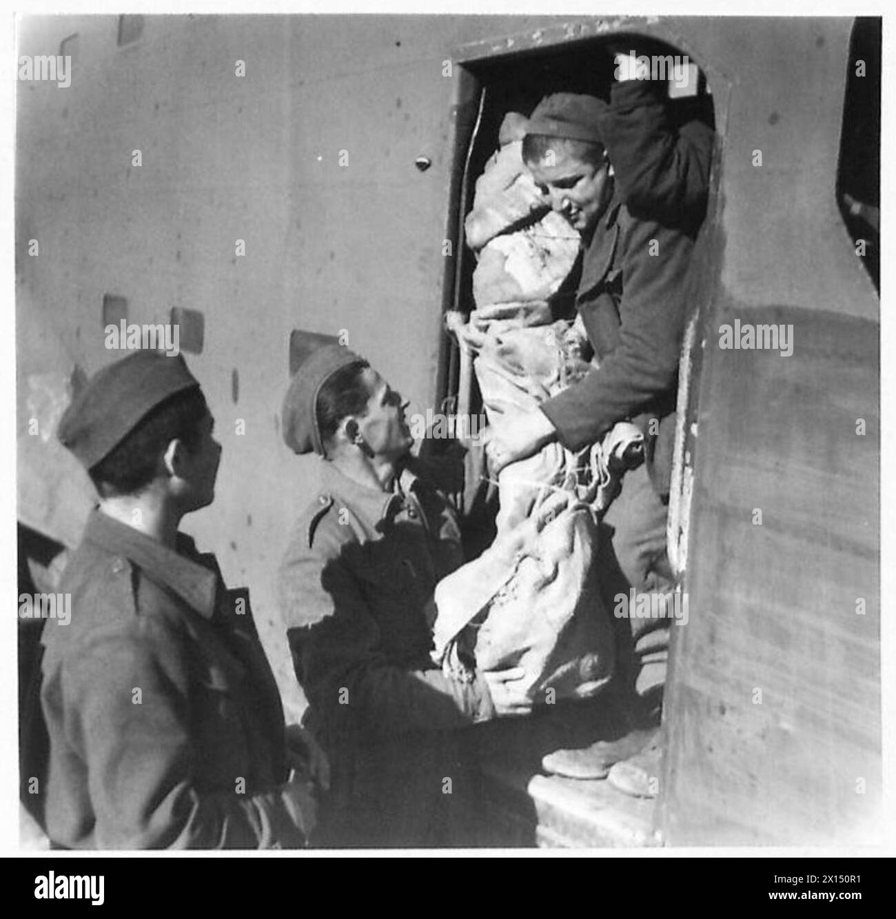 Le truppe partigiane in Jugoslavia scaricano aerei da trasporto che trasportano compo razioni, mitragliatrici Bren ed esplosivi missilistici per aerei che sparano razzi. Foto Stock