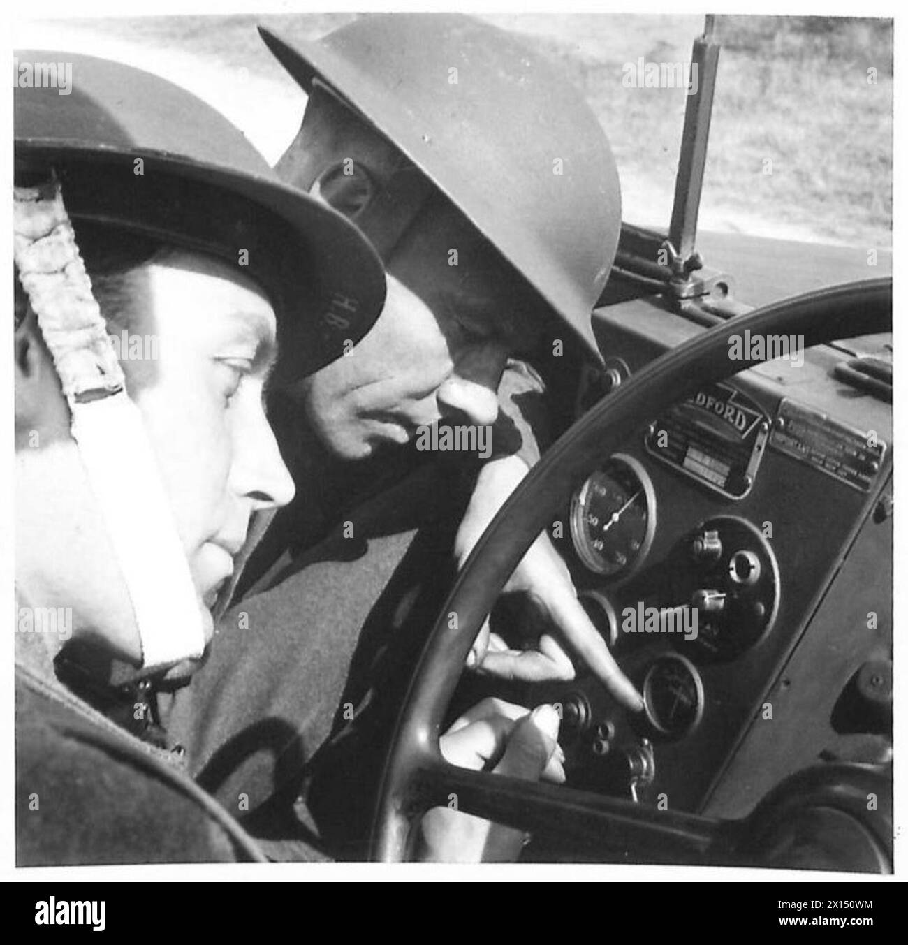 Un istruttore e un tirocinante esaminano il cruscotto di un veicolo durante gli esercizi di addestramento di piloti militari e motociclisti. Foto Stock