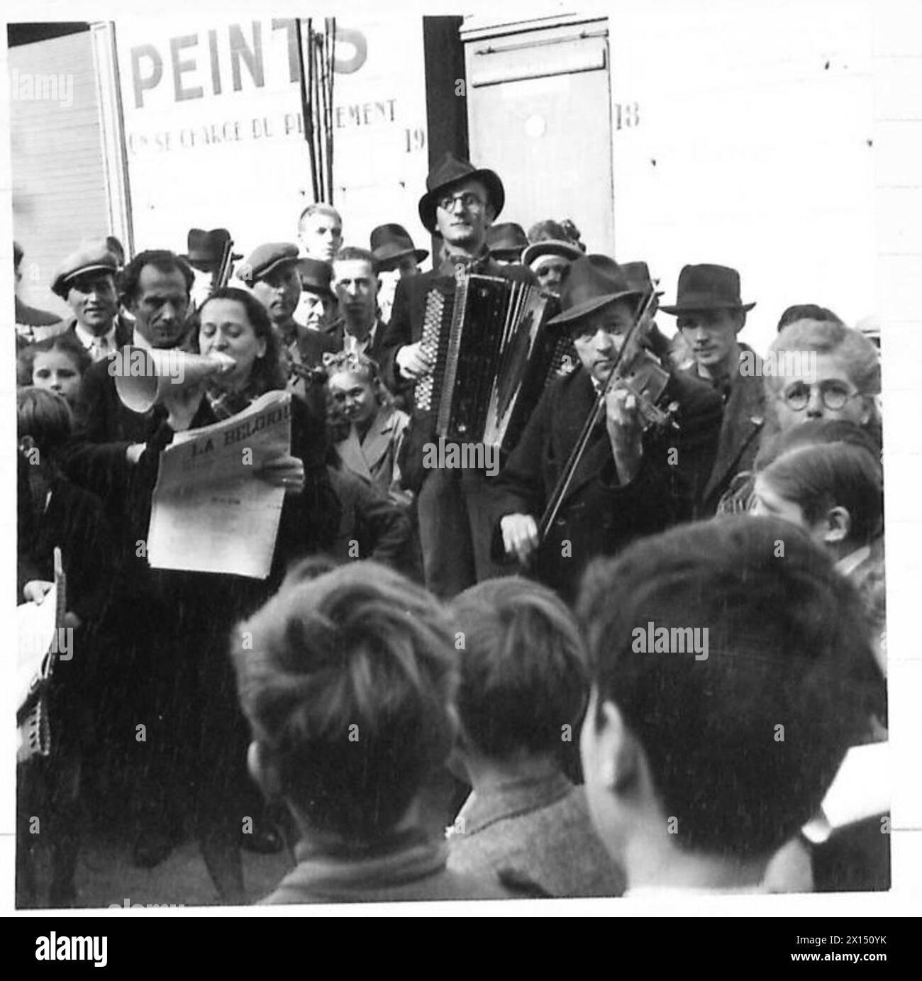 Il mercato domenicale mattutino di Bruxelles illustra i cittadini belgi che acquistano beni tra cui cibo, libri, hardware e parti del ciclo durante la guerra, British Army, 21st Army Group Foto Stock