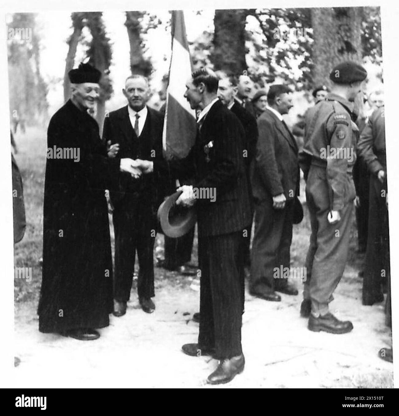 Un prete stringe la mano a un membro della Old Comrades Association durante le celebrazioni del giorno della Bastiglia in Normandia con l'esercito britannico, 21st Army Group. Foto Stock