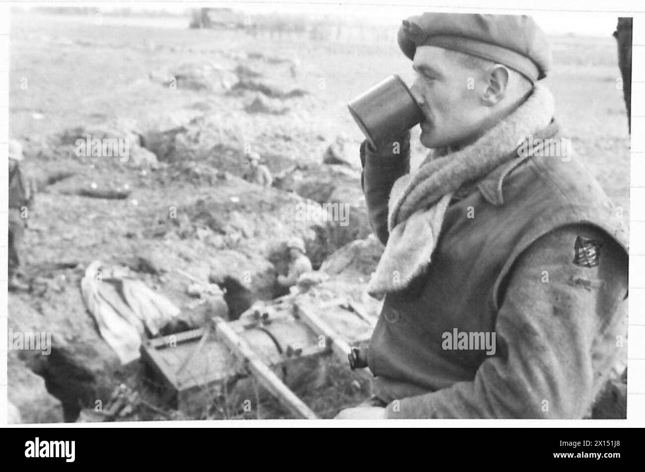 Il tenente T. Crotty, un ufficiale irlandese, beve tè accanto alle trincee americane fuori Geilenkirchen durante le operazioni dell'esercito britannico, 21st Army Group. Foto Stock