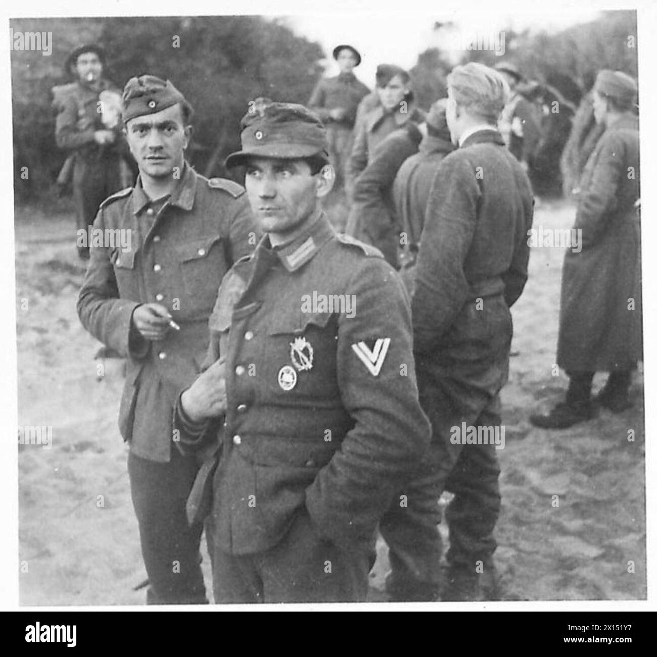 Durante le prime fasi degli sbarchi alleati a sud di Roma, i prigionieri sono tenuti sulla spiaggia sotto la guardia dell'esercito britannico. Foto Stock
