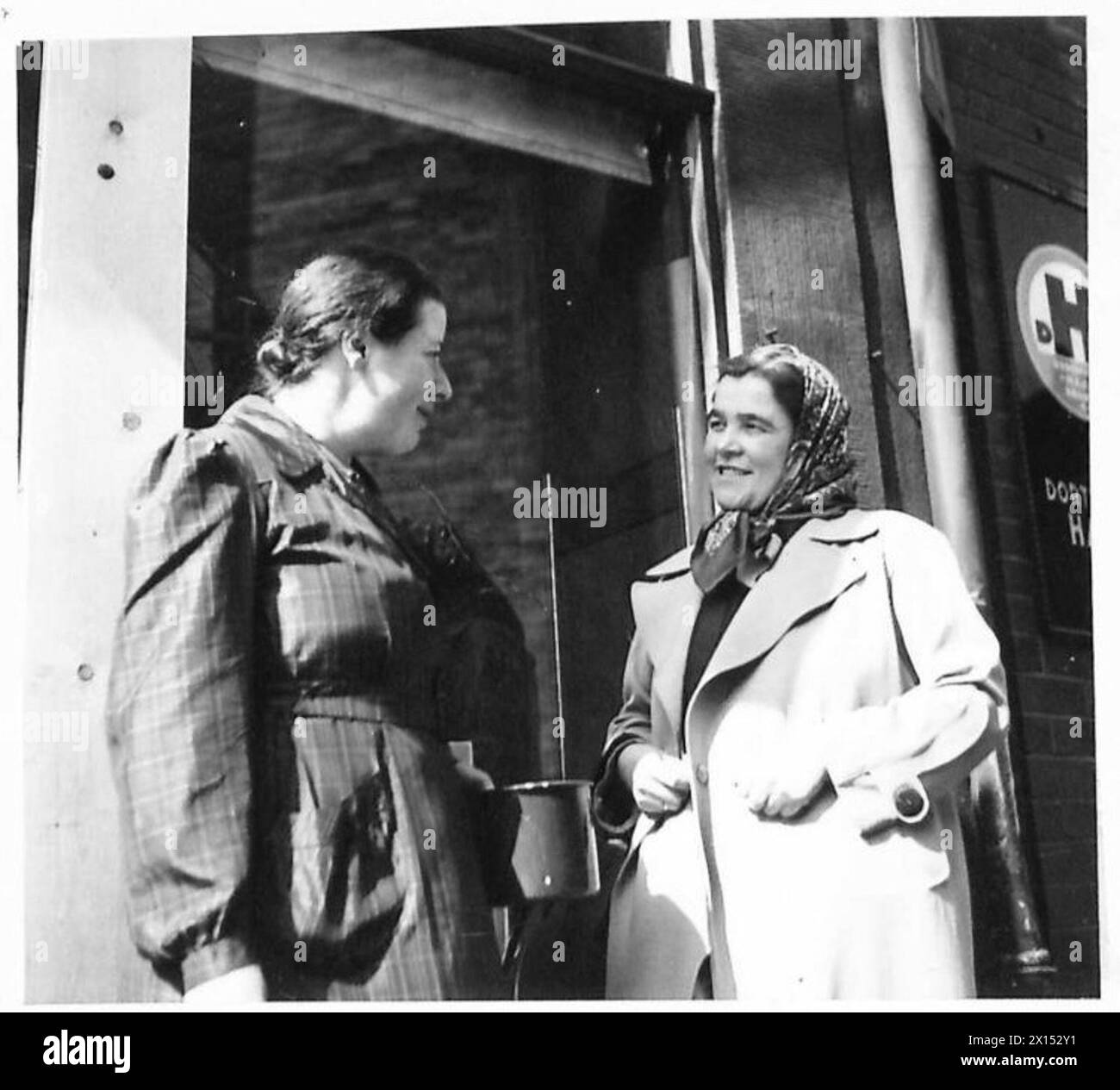 I civili tedeschi, comprese le donne, hanno letto la proclamazione ufficiale di fine guerra, che segna la conclusione della seconda guerra mondiale nella loro zona. Foto Stock