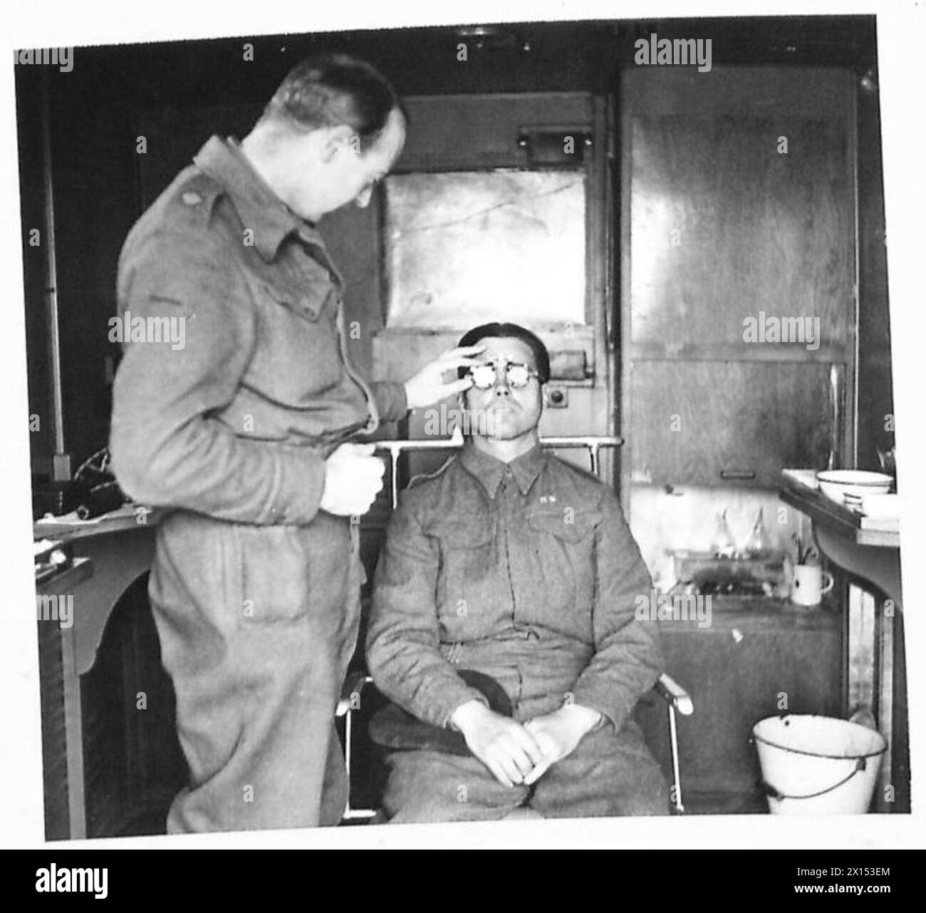 Il maggiore H.M. Patton della RAMC, un ex ottico, mette alla prova gli occhi di un soldato alla ricerca di occhiali al Quinta Esercito Oftalmico Service in Italia. Foto Stock