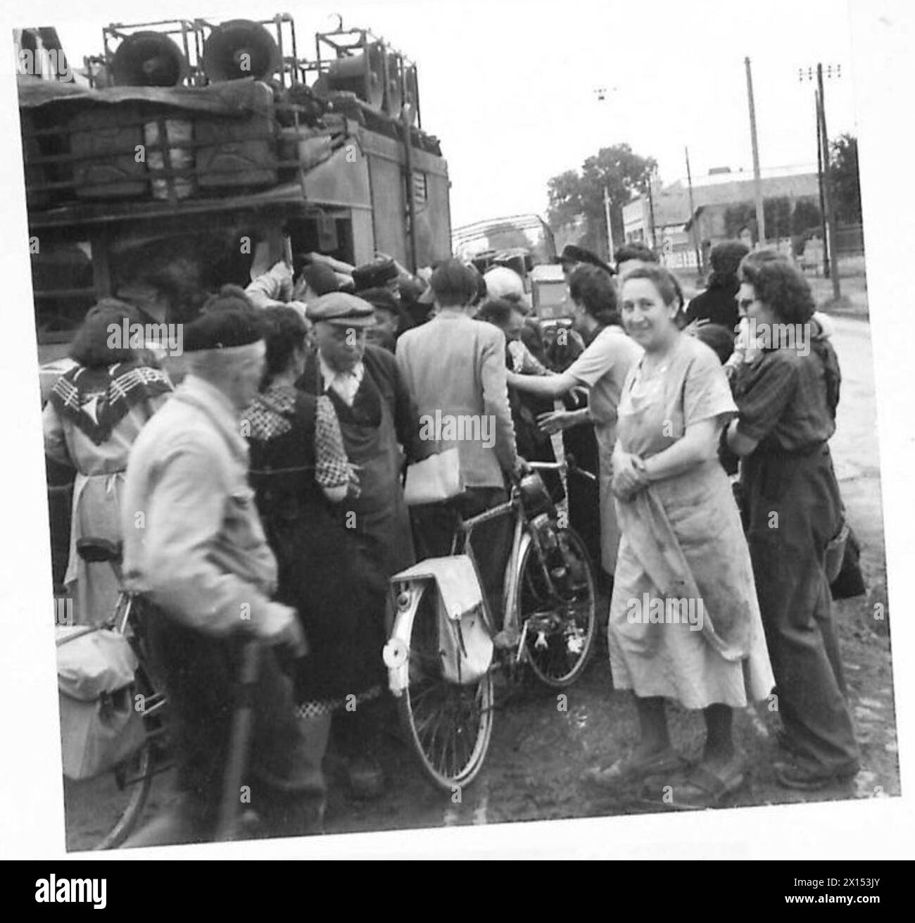 I civili a Caen si arrampicano per ottenere copie del giornale francese di liberazione "la Voix des Allies". Foto Stock