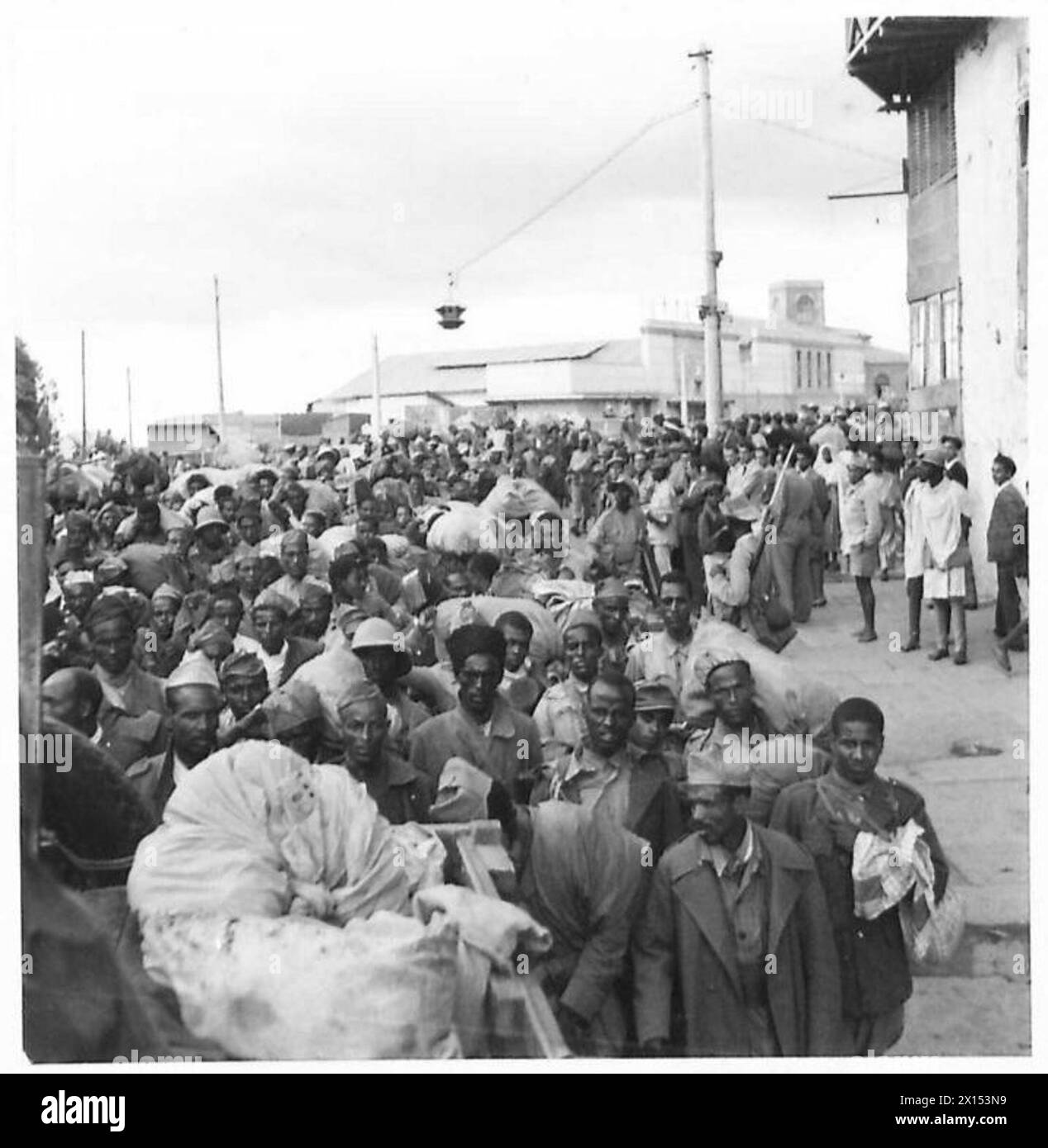 La fanteria coloniale italiana catturata riposò durante una marcia attraverso Addis Abeba, Etiopia, mostrando truppe in uniforme militare coloniale. Foto Stock