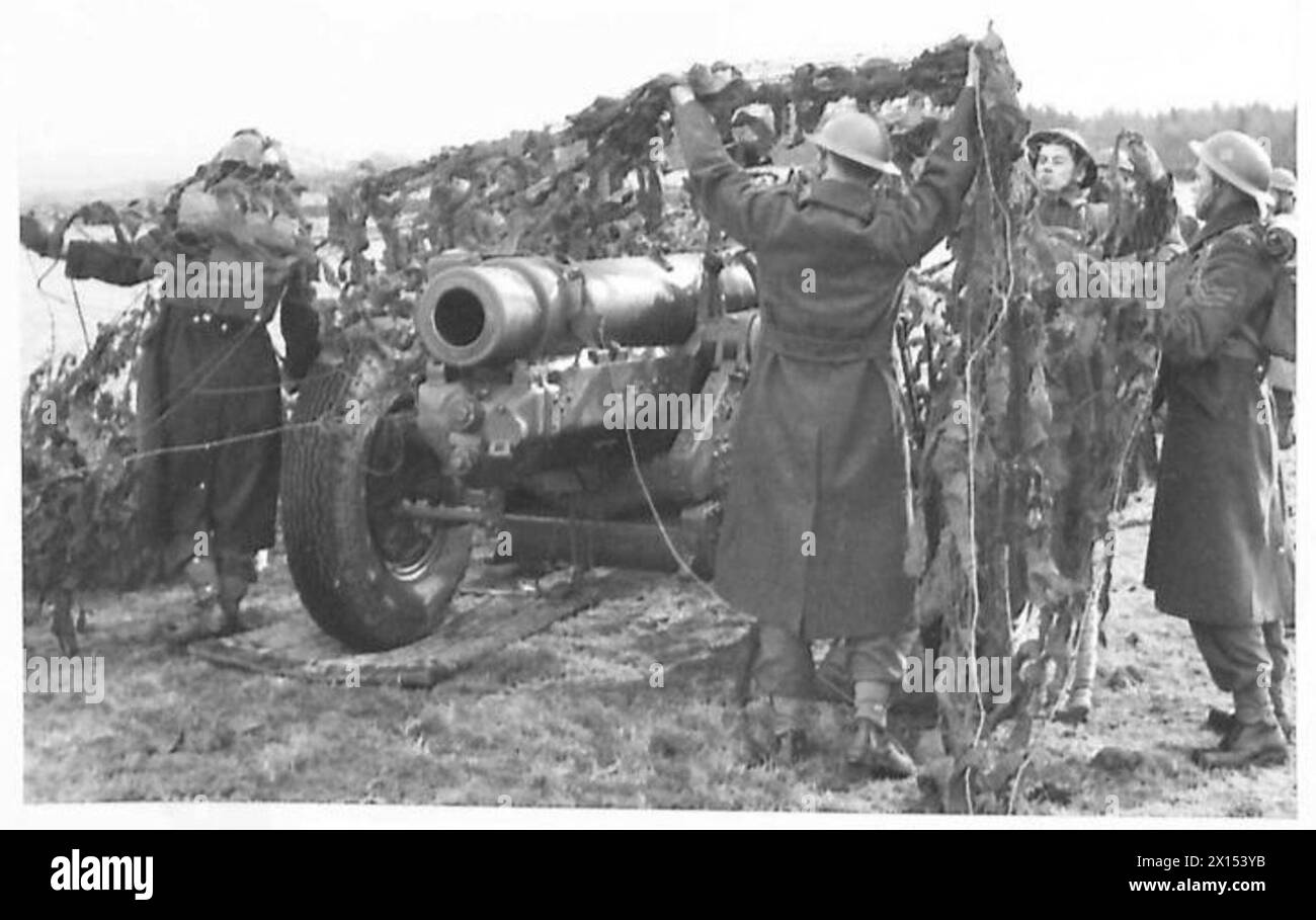 Le truppe posizionano una rete mimetica su una pistola in Scozia per nasconderla all'osservazione aerea durante gli esercizi. Foto Stock
