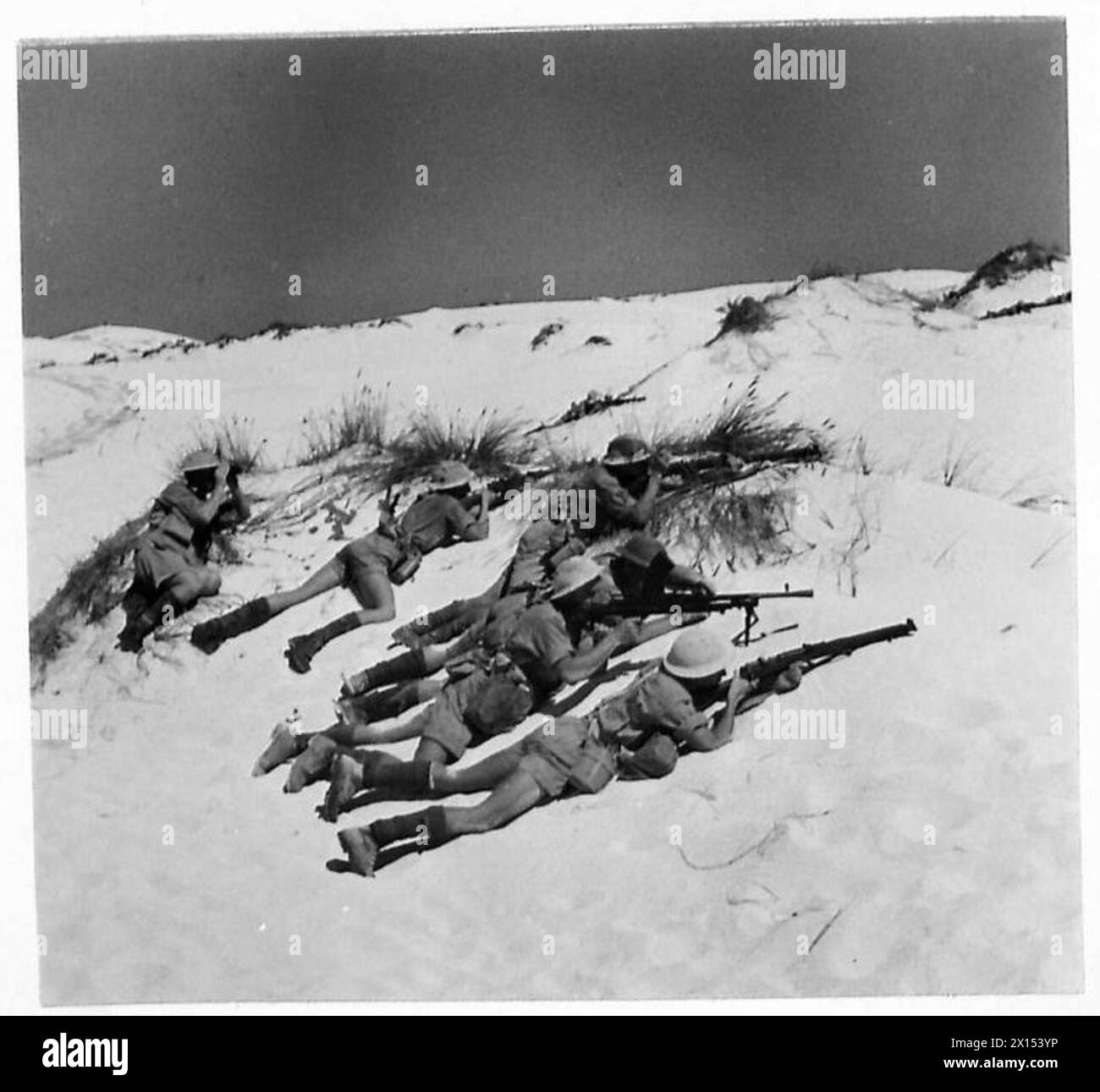 Una pattuglia sudafricana operante nel deserto occidentale viene mostrata mentre si ripara da una pattuglia nemica durante le operazioni dell'esercito britannico. Foto Stock