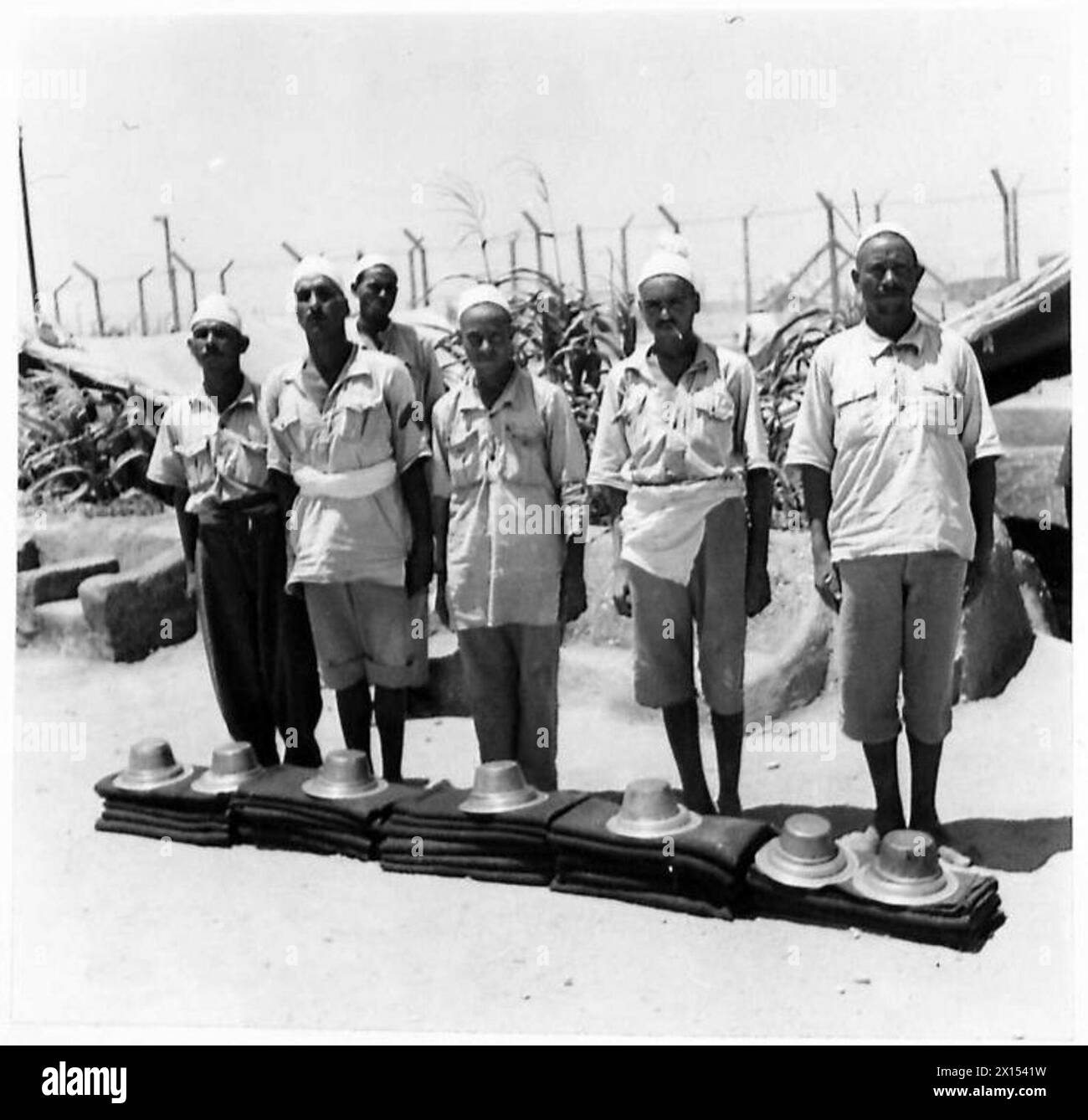 I prigionieri in un campo dell'esercito britannico in Libia stanno accanto al loro kit personale per l'ispezione. Foto Stock